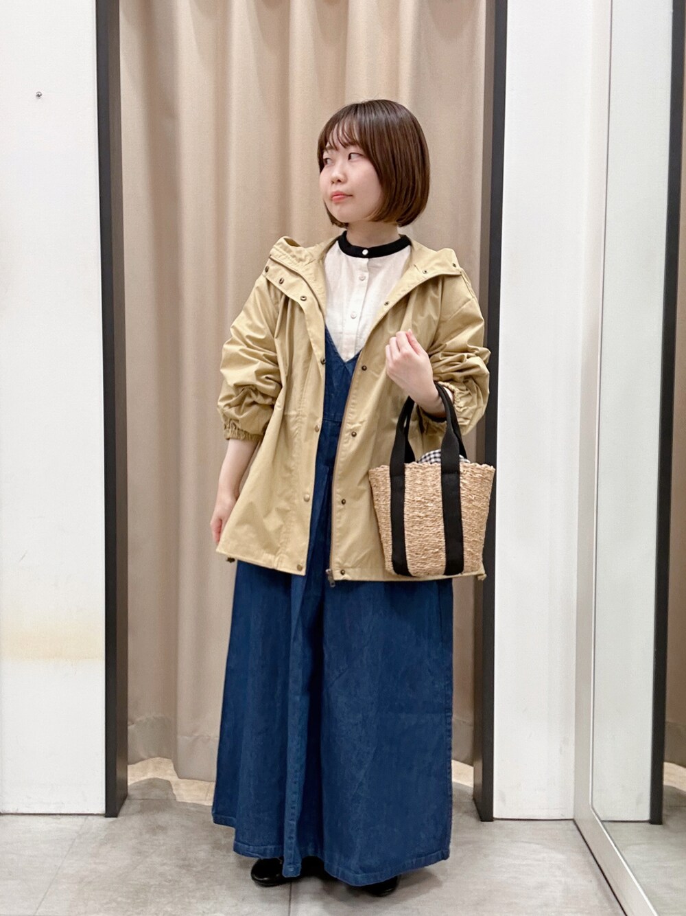 ブラック系のドレスシューズ、ホワイト系のチュニック、ベージュ系のブルゾンを着用したレディースの春コーディネートの1枚目の写真