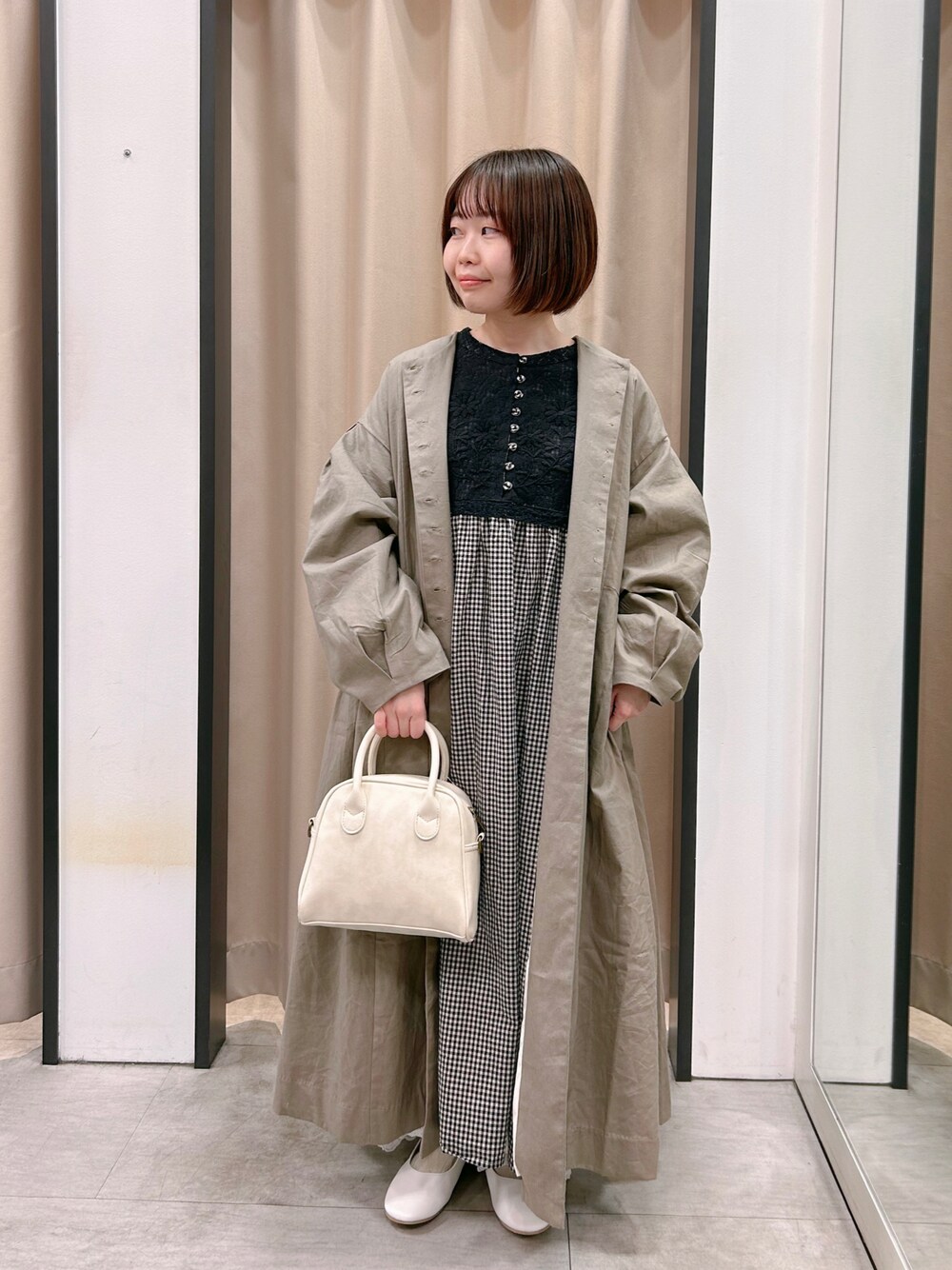 グレー系のワンピース、ホワイト系のドレスシューズ、ホワイト系のパンツを着用したレディースの冬コーディネートの1枚目の写真