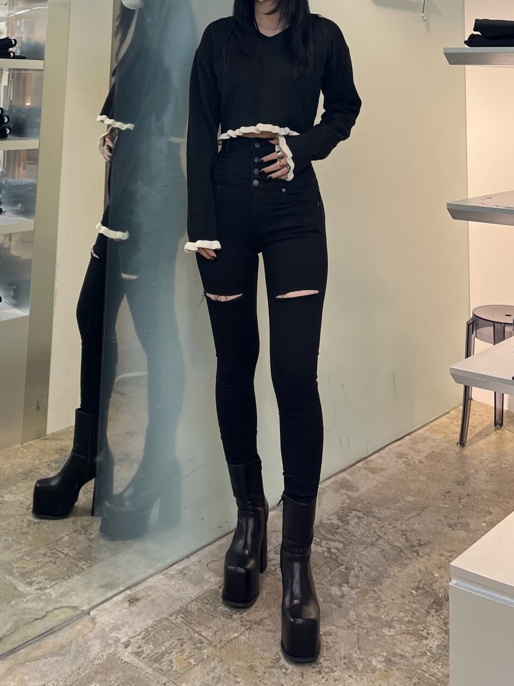 ブラック系のニット/セーター、ブラック系のデニムパンツ、ブラック系のブーツを着用したレディースの冬コーディネートの1枚目の写真