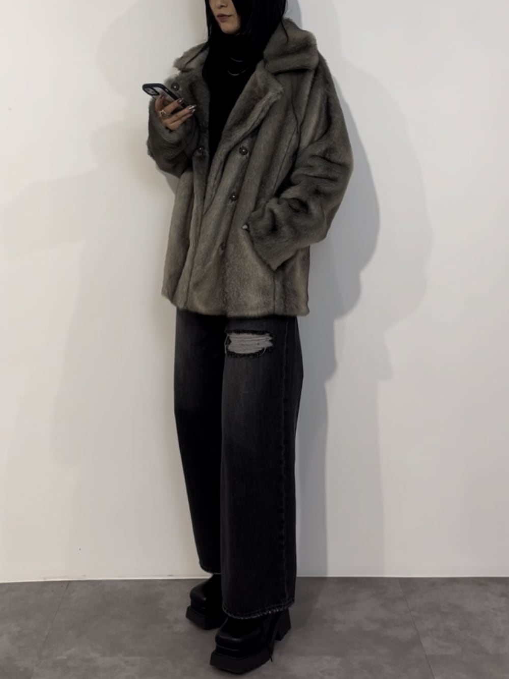 ブラック系のニット/セーター、グレー系のその他アウター、ブラック系のデニムパンツを着用したレディースの冬コーディネートの1枚目の写真