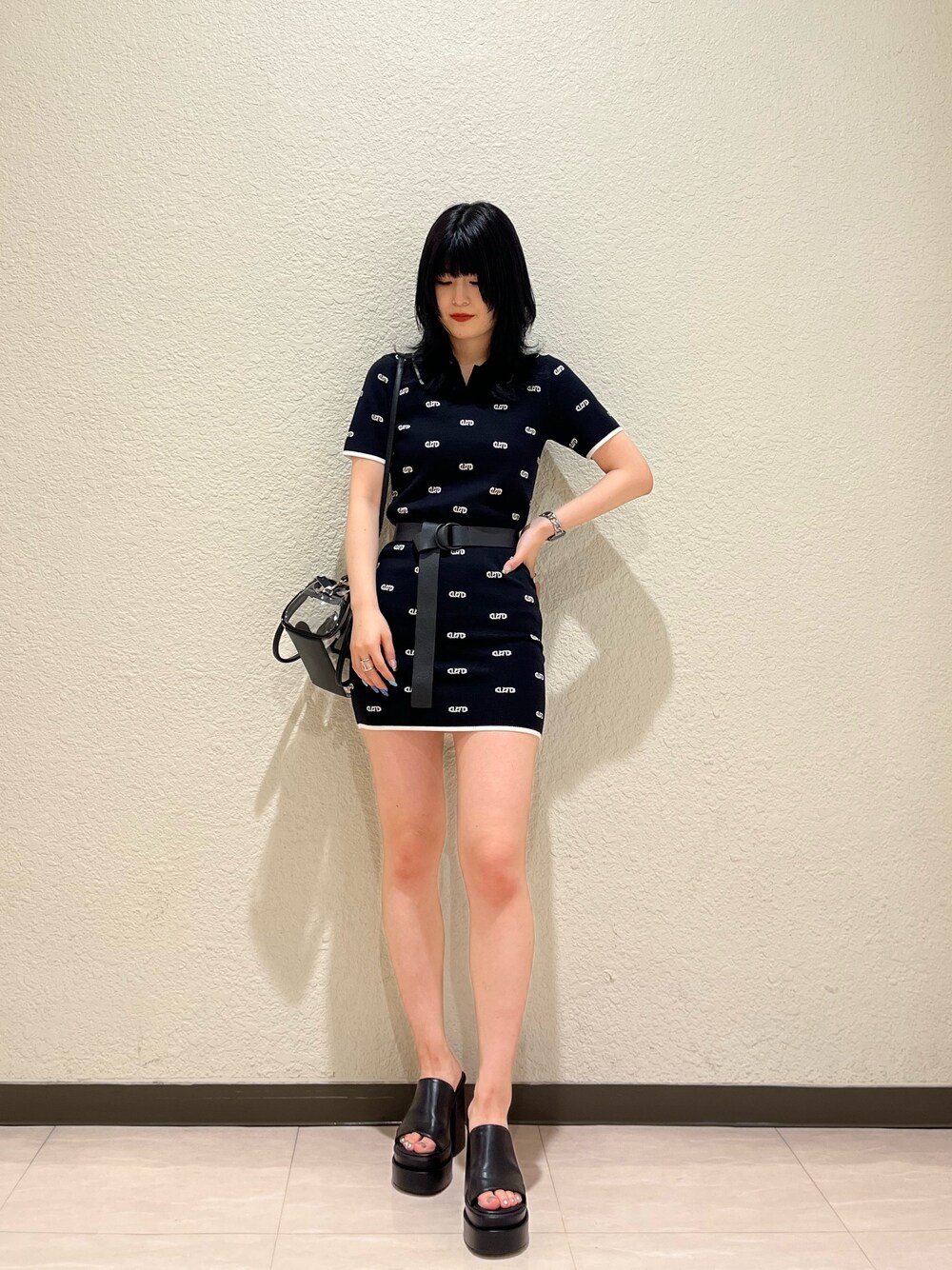 ブラック系のワンピース、その他のハンドバッグ、ブラック系のサンダルを着用したレディースの春コーディネートの1枚目の写真