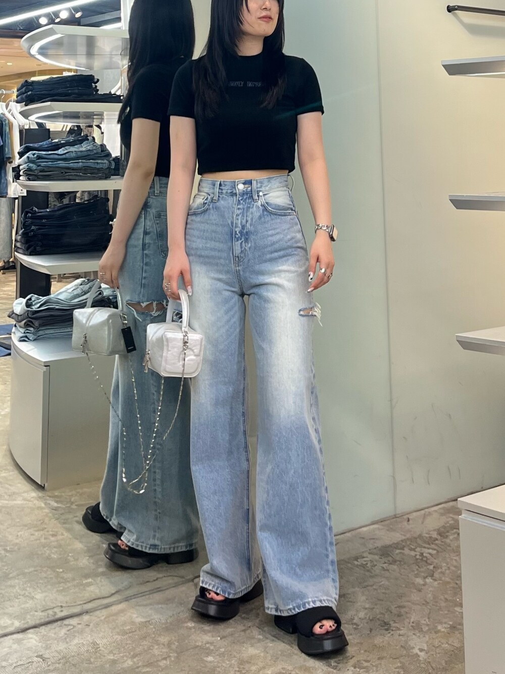 ブラック系のTシャツ/カットソー、ブルー系のデニムパンツ、シルバー系のハンドバッグを着用したレディースの夏コーディネートの1枚目の写真
