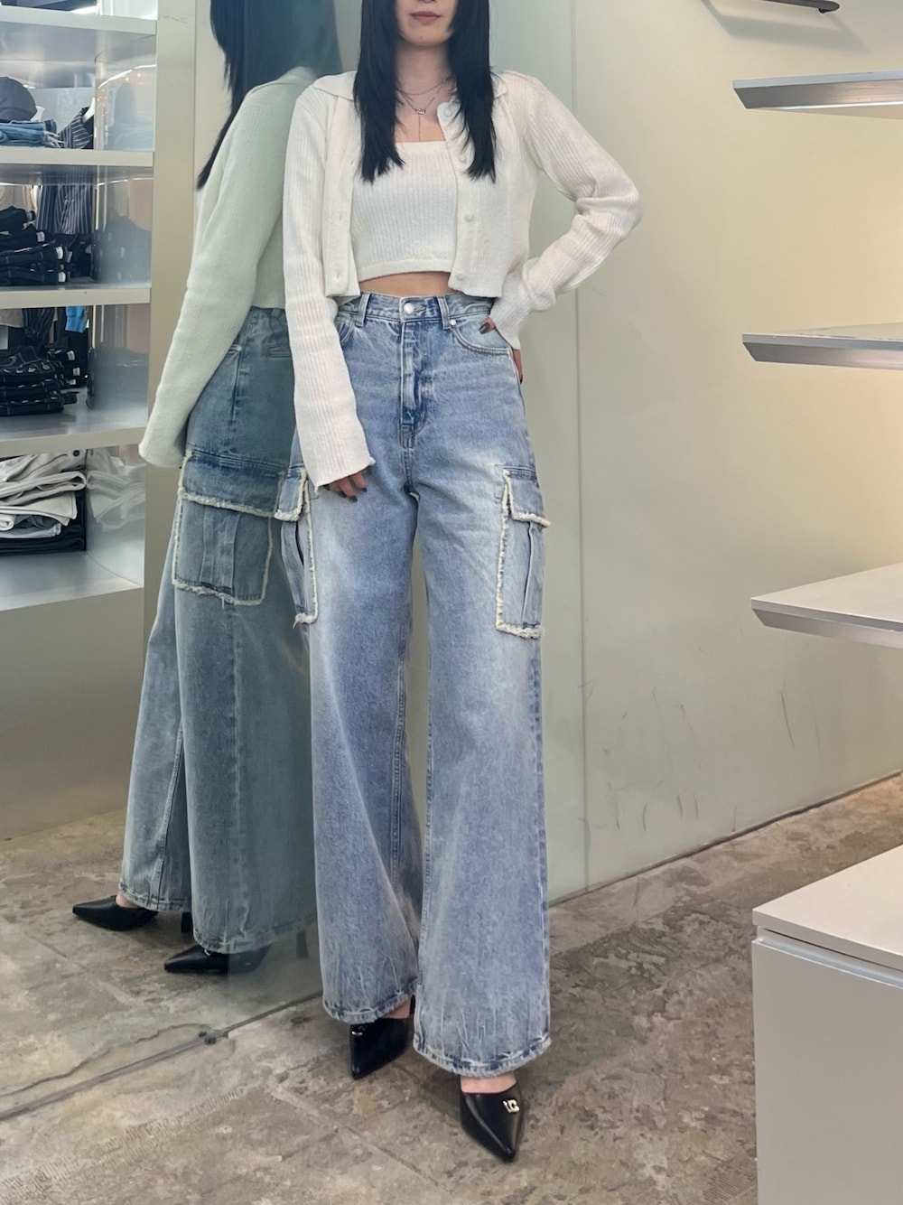 ホワイト系のニット/セーター、ブルー系のデニムパンツ、ブラック系のパンプスを着用したレディースの春コーディネートの1枚目の写真