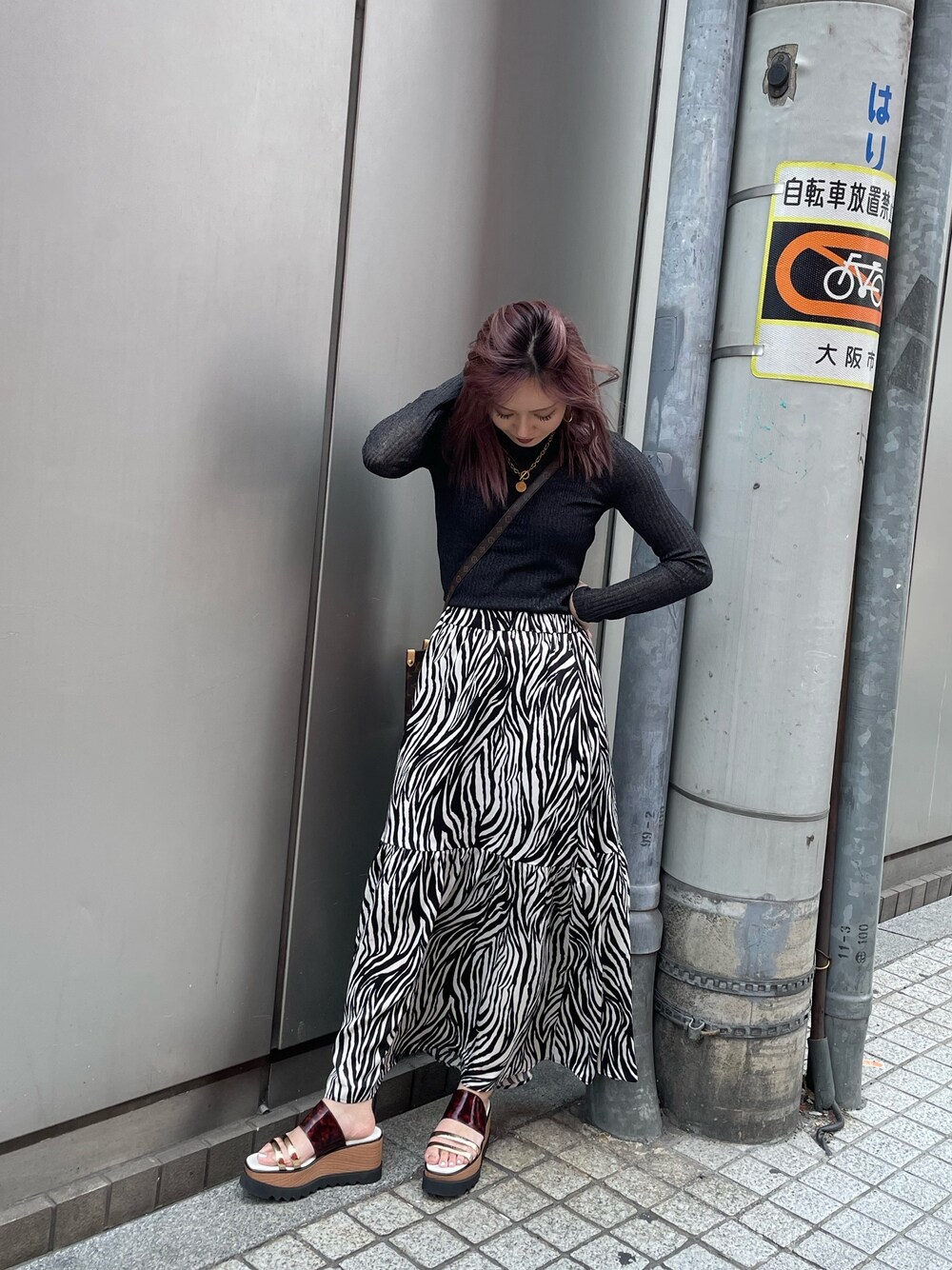 ブラック系のニット/セーター、ホワイト系のスカート、その他のサンダルを着用したレディースの春コーディネートの1枚目の写真