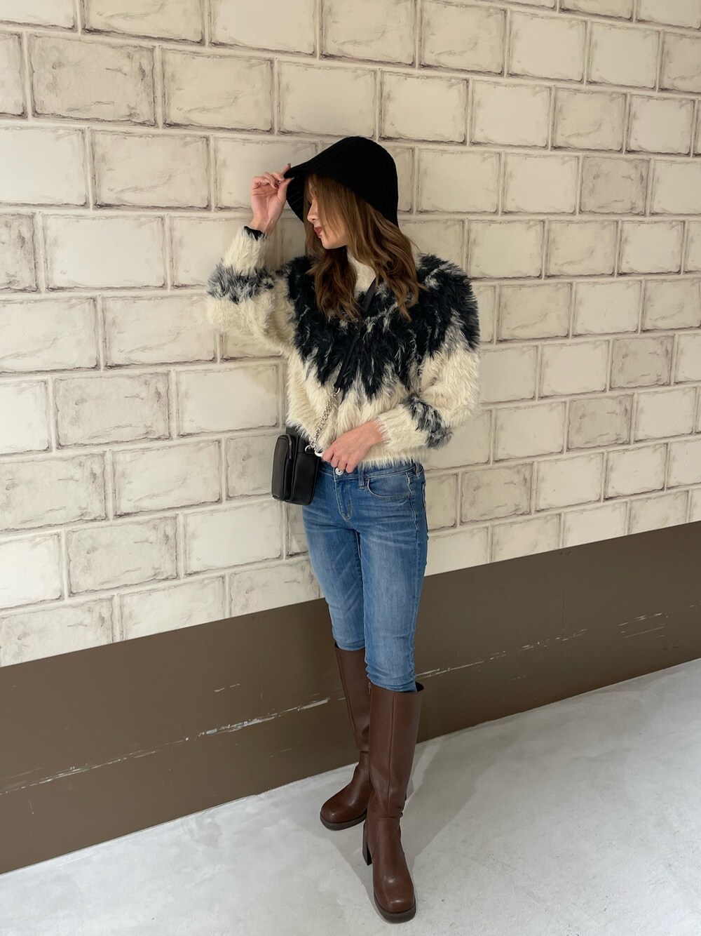 ホワイト系のニット/セーター、ブラウン系のブーツ、ブラック系のハットを着用したレディースの秋コーディネートの1枚目の写真