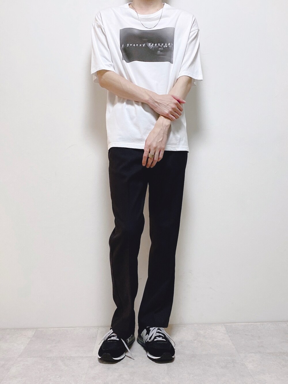 ホワイト系のTシャツ/カットソー、ブラック系のスラックス、ブラック系のスニーカーを着用したメンズの夏コーディネートの1枚目の写真