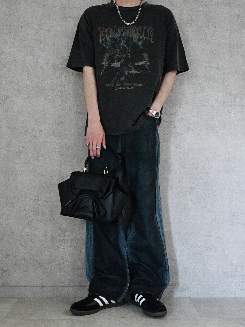 グレー系のTシャツ/カットソー、ブラック系のデニムパンツ、ブラック系のハンドバッグを着用したメンズの春コーディネートの1枚目の写真