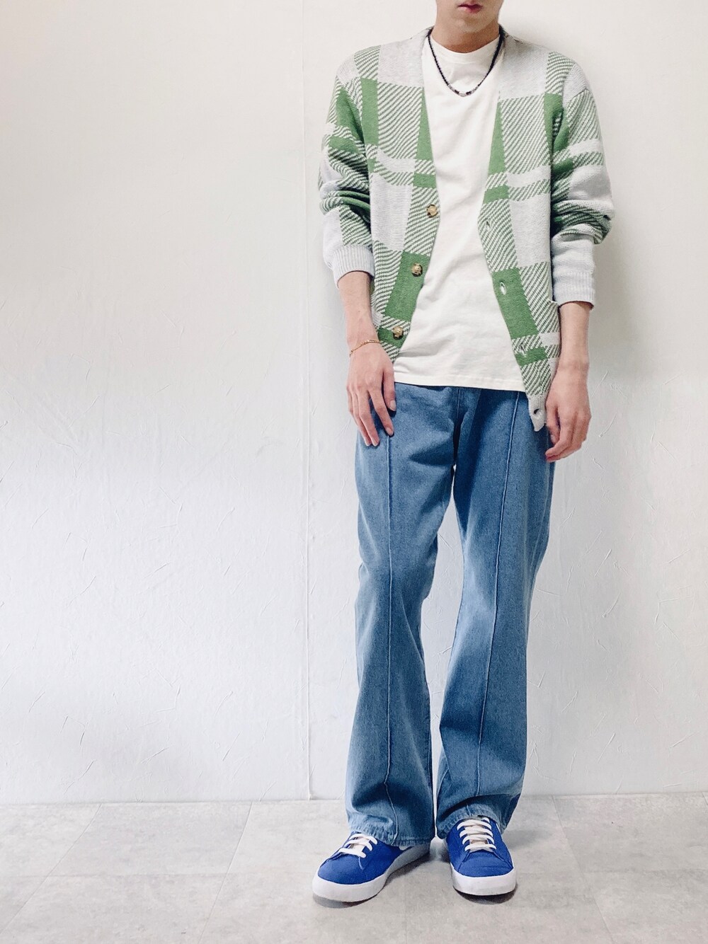 グリーン系のカーディガン/ボレロ、ブルー系のスラックス、ブルー系のスニーカーを着用したメンズの春コーディネートの1枚目の写真