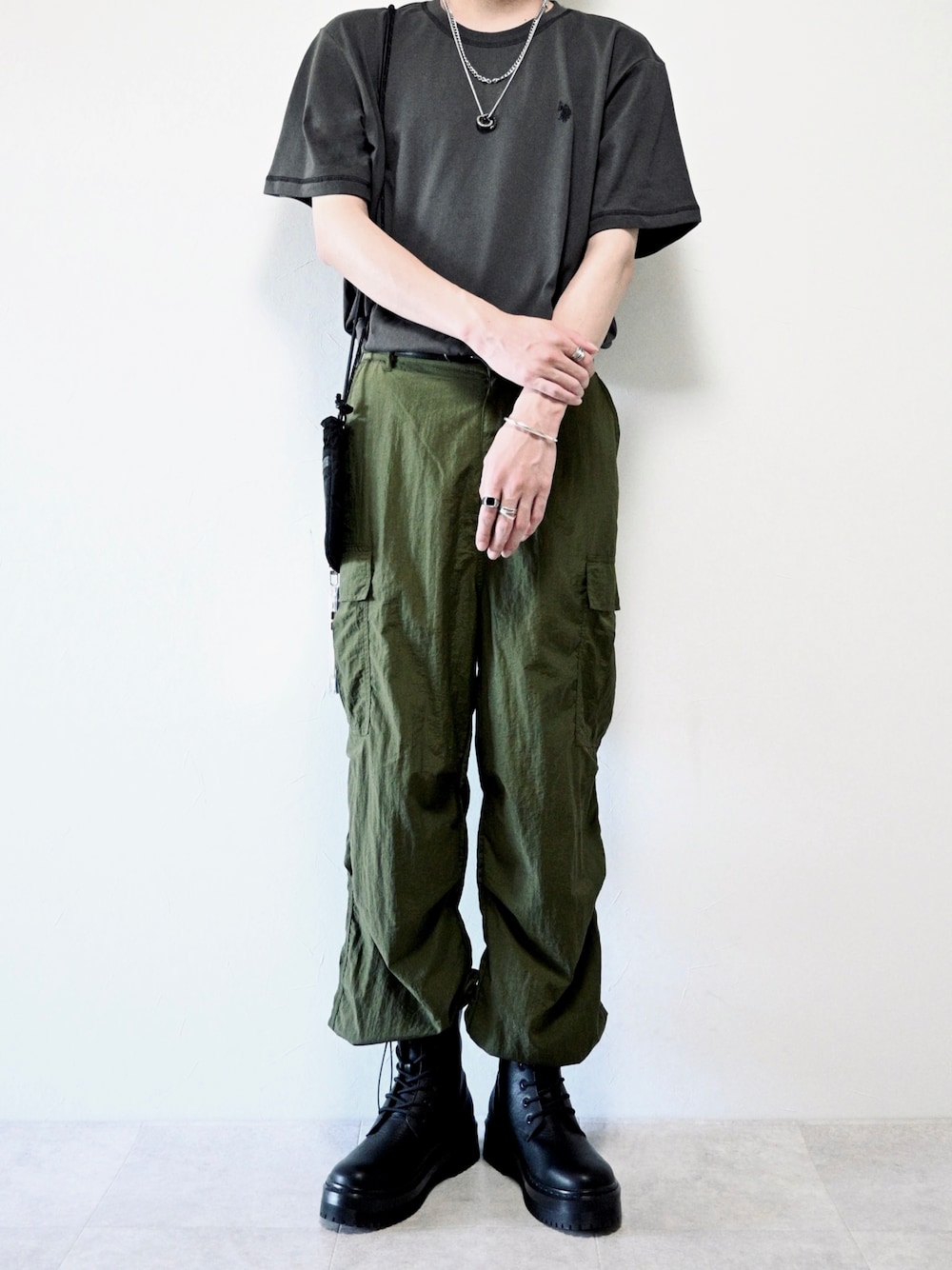 グレー系のTシャツ/カットソー、グリーン系のカーゴパンツ、ブラック系のブーツを着用したメンズの夏コーディネートの1枚目の写真