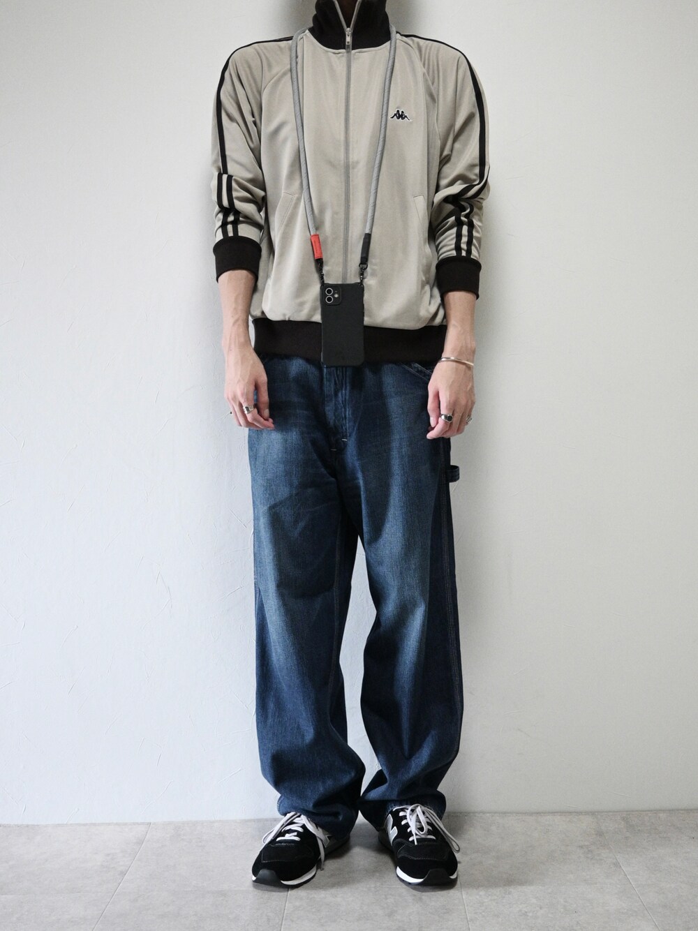 ベージュ系のジャージ、ブルー系のデニムパンツ、ブラック系のスニーカーを着用したメンズの秋コーディネートの1枚目の写真