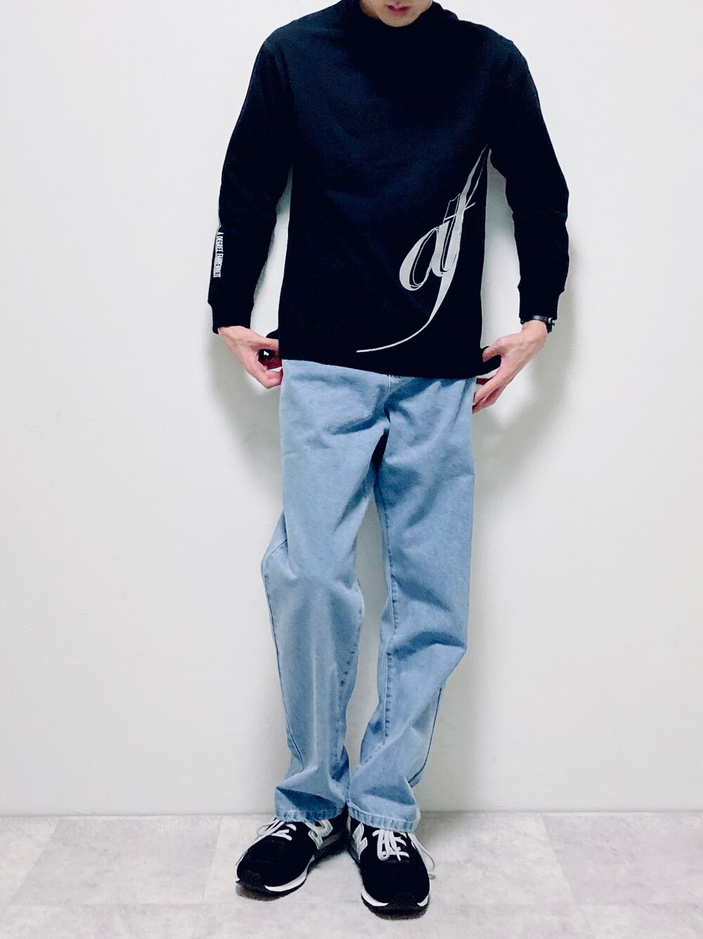 ブラック系のTシャツ/カットソー、ブルー系のデニムパンツ、ブラック系のスニーカーを着用したメンズの冬コーディネートの1枚目の写真