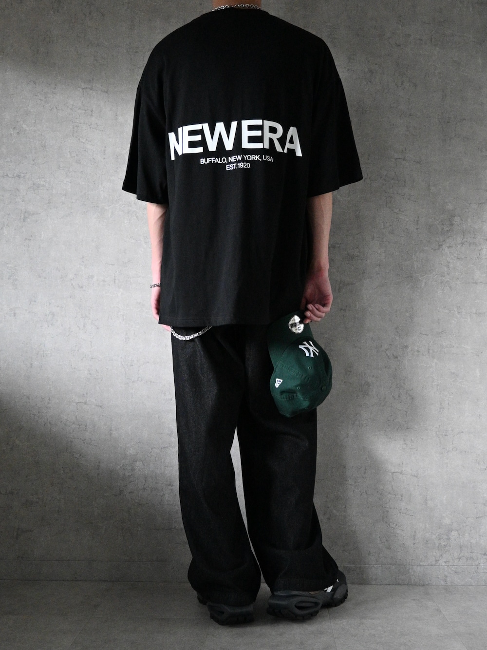 グレー系のデニムパンツ、ブラック系のTシャツ/カットソー、ブラック系のスニーカーを着用したメンズの夏コーディネートの1枚目の写真