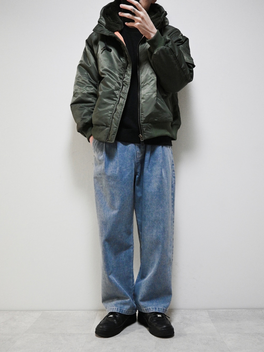 ブルー系のデニムパンツ、グリーン系のMA-1、シルバー系のリングを着用したメンズの冬コーディネートの1枚目の写真