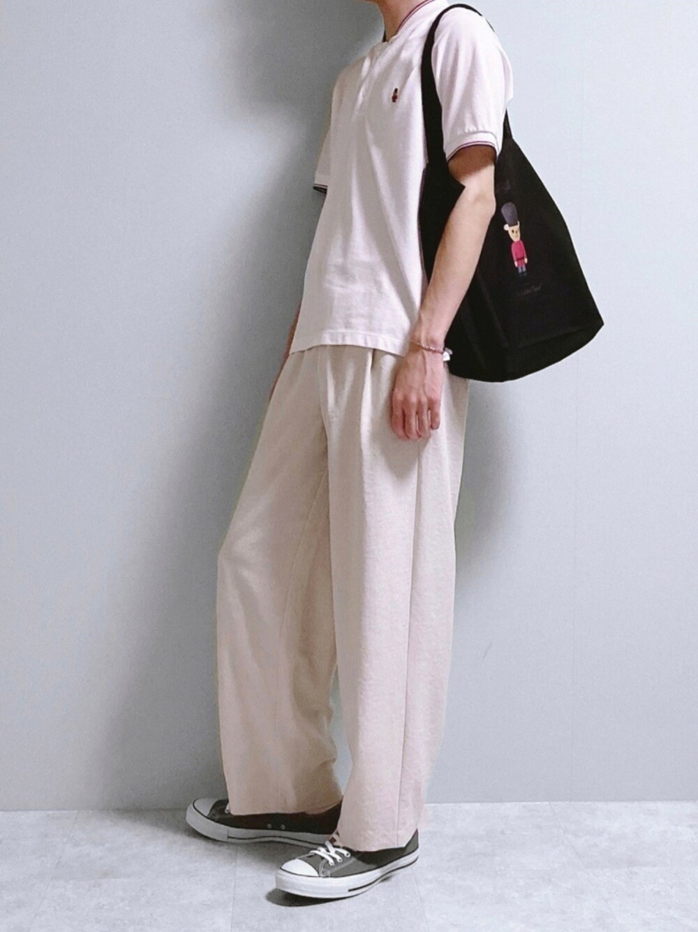 ホワイト系のポロシャツ、ブラック系のトートバッグ、ホワイト系のその他パンツを着用したメンズの夏コーディネートの1枚目の写真