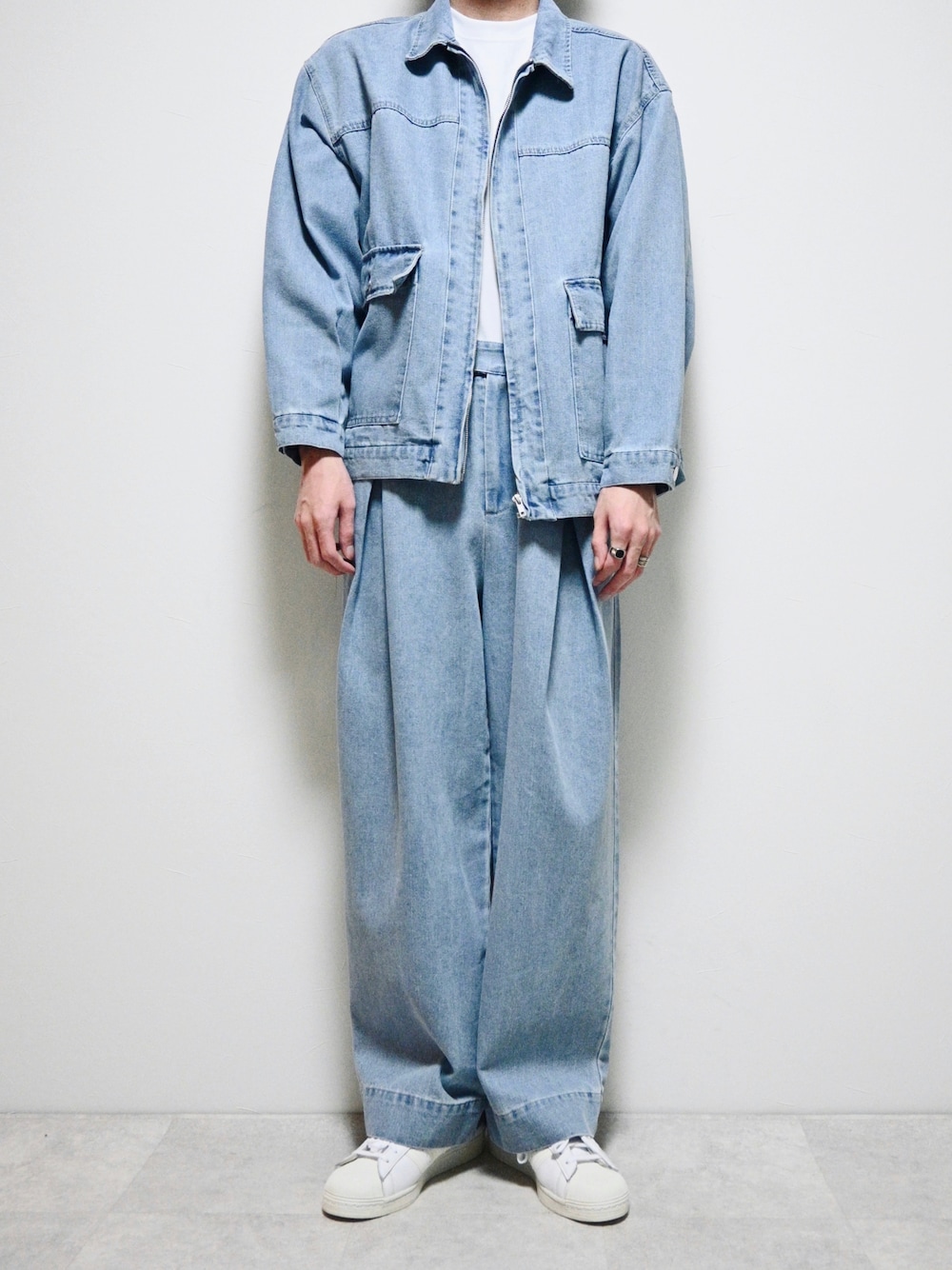 ブルー系のデニムジャケット、ブルー系のデニムパンツ、ホワイト系のスニーカーを着用したメンズの春コーディネートの1枚目の写真