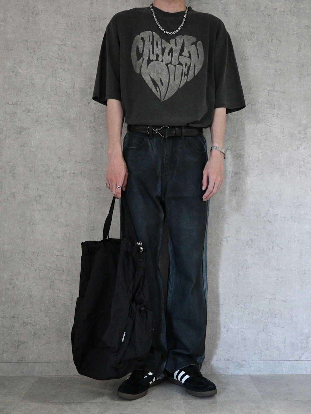 ブラック系のTシャツ/カットソー、ブラック系のバックパック/リュック、ブラック系のデニムパンツを着用したメンズの春コーディネートの1枚目の写真