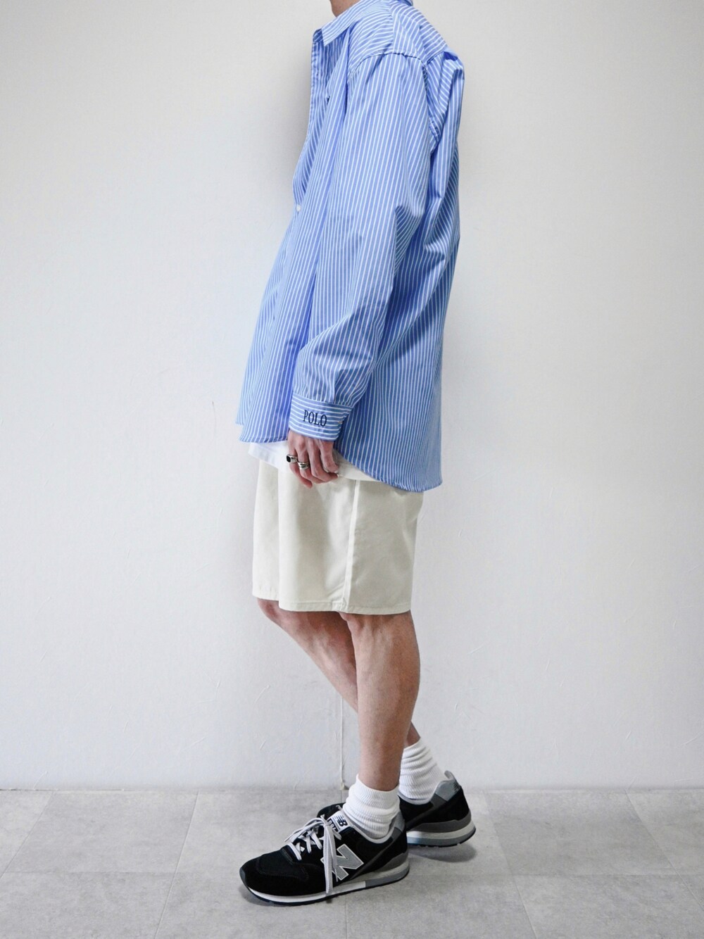 ホワイト系のデニムパンツ、ブルー系のシャツ/ブラウス、ブラック系のスニーカーを着用したメンズの春コーディネートの1枚目の写真
