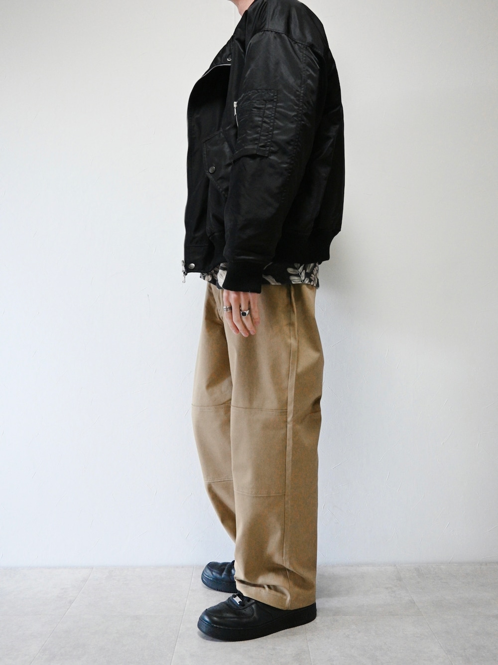 ベージュ系のチノパンツ、ブラック系のMA-1、ブラック系のリングを着用したメンズの春コーディネートの1枚目の写真