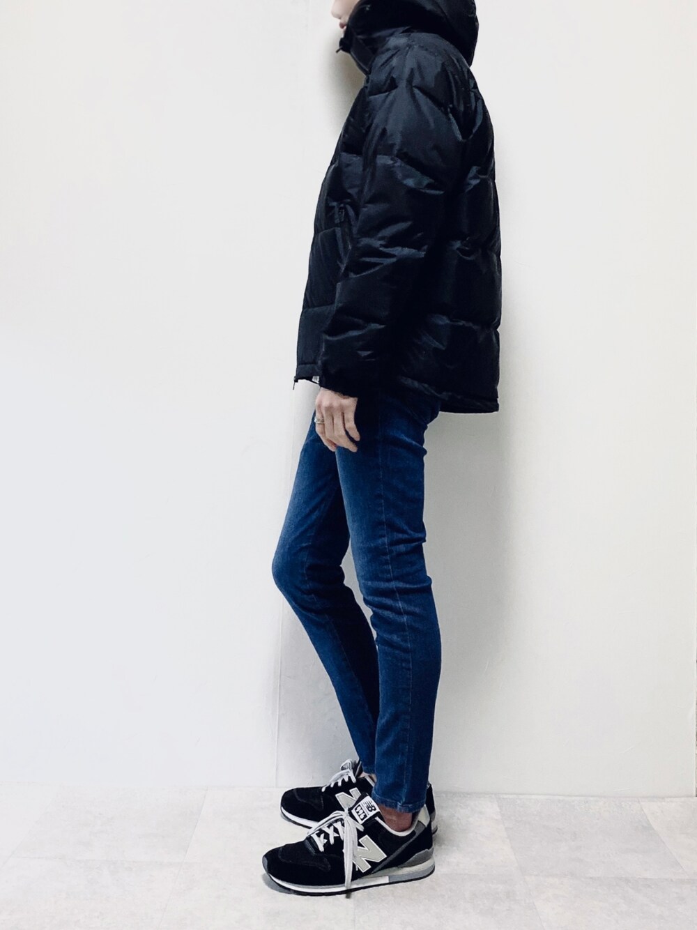 ブラック系のダウンジャケット/コート、ブルー系のデニムパンツ、ブラック系のスニーカーを着用したメンズの冬コーディネートの1枚目の写真