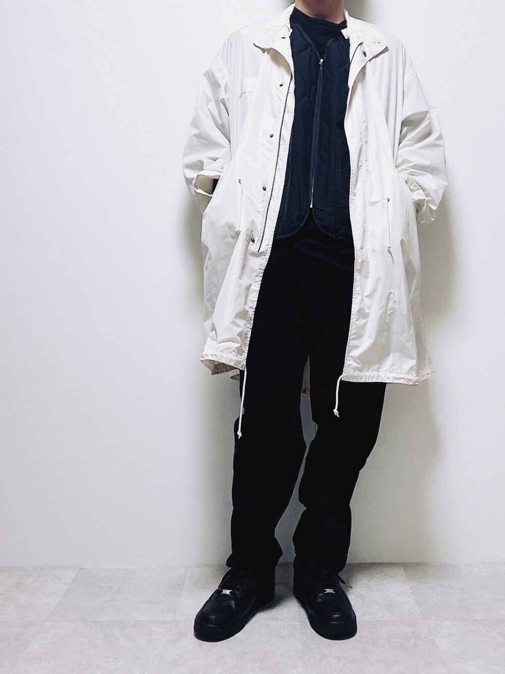 ブラック系のベスト、ブラック系のその他パンツ、ホワイト系のモッズコートを着用したメンズの秋コーディネートの1枚目の写真