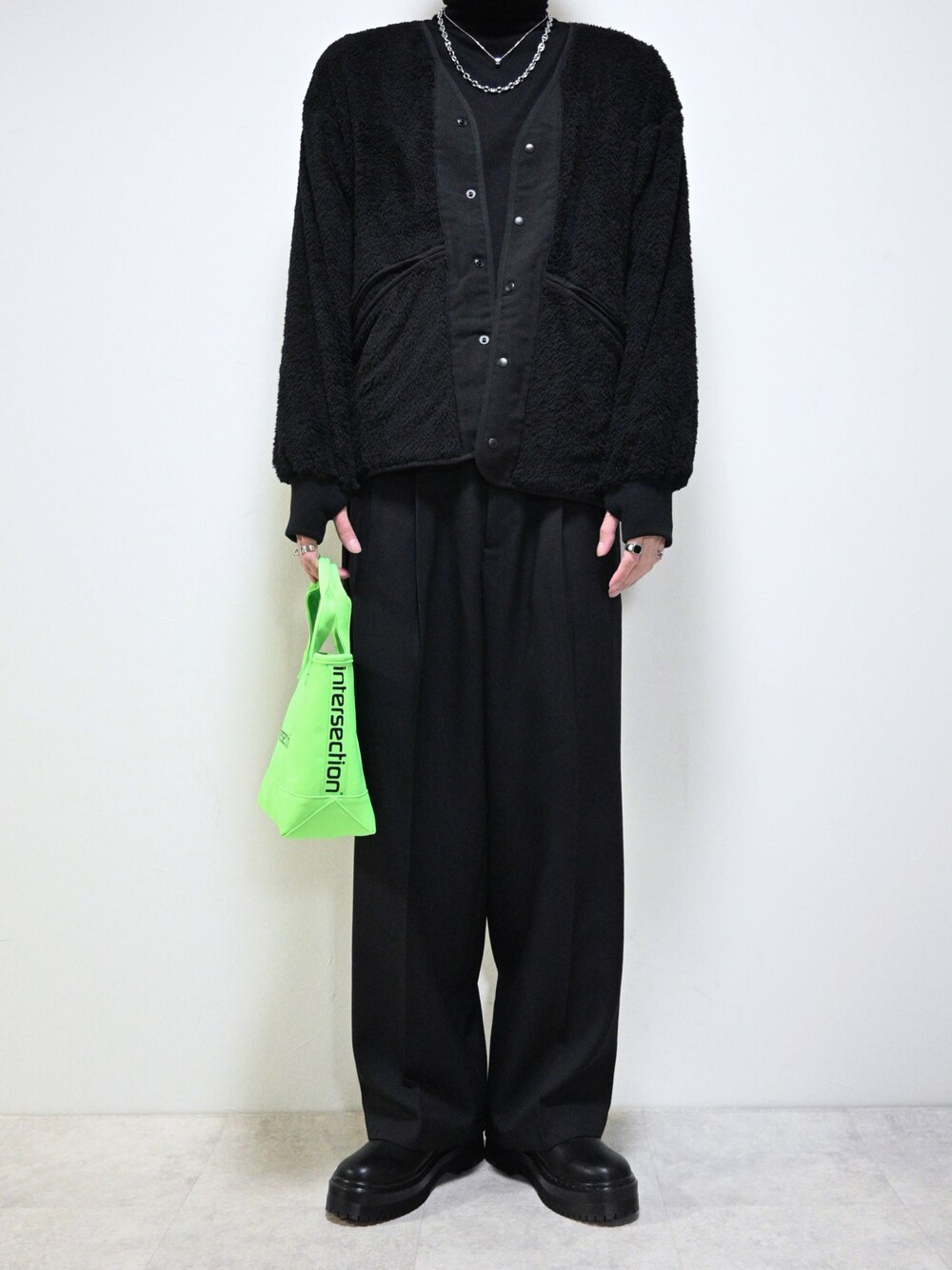 ブラック系のジャケット/アウター、グリーン系のトートバッグ、ブラック系のブーツを着用したメンズの冬コーディネートの1枚目の写真