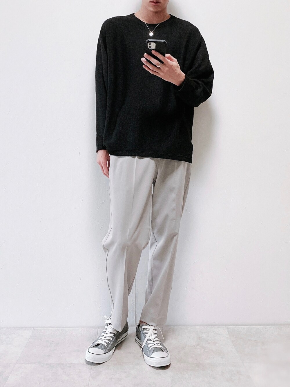 グレー系のその他パンツ、グレー系のスニーカー、ブラック系のニット/セーターを着用したメンズの秋コーディネートの1枚目の写真
