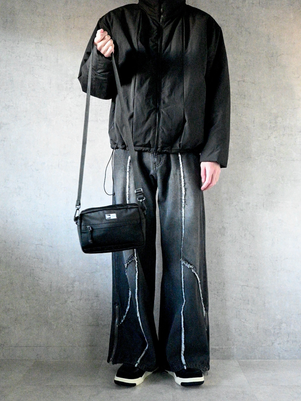 ブラック系のダウンジャケット/コート、ブラック系のデニムパンツ、ブラック系のショルダーバッグを着用したメンズの冬コーディネートの1枚目の写真