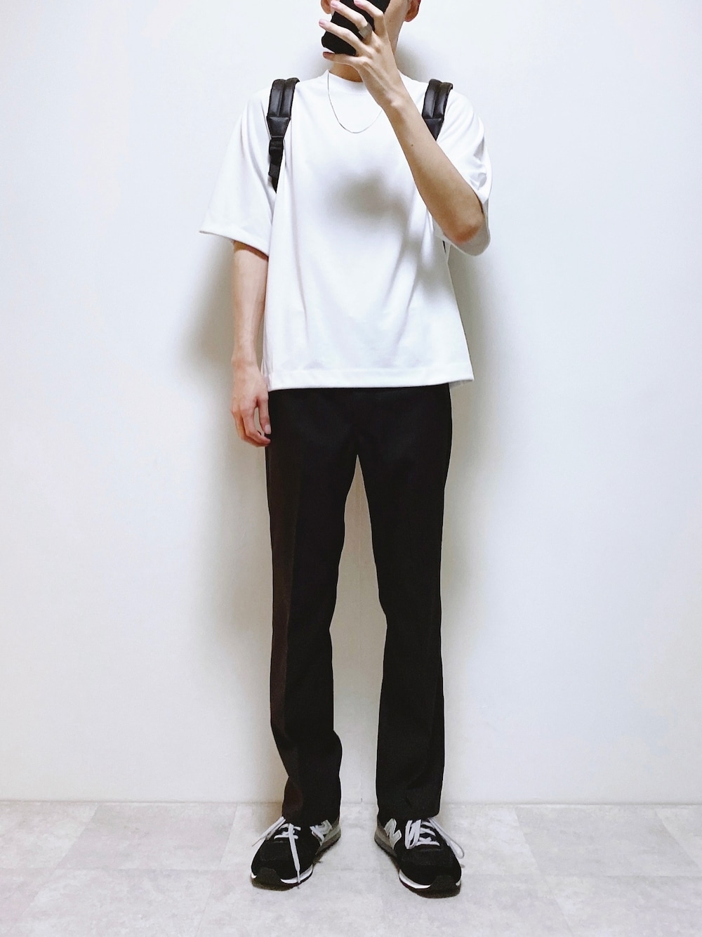 ホワイト系のTシャツ/カットソー、ブラック系のスラックス、ブラック系のスニーカーを着用したメンズの夏コーディネートの1枚目の写真