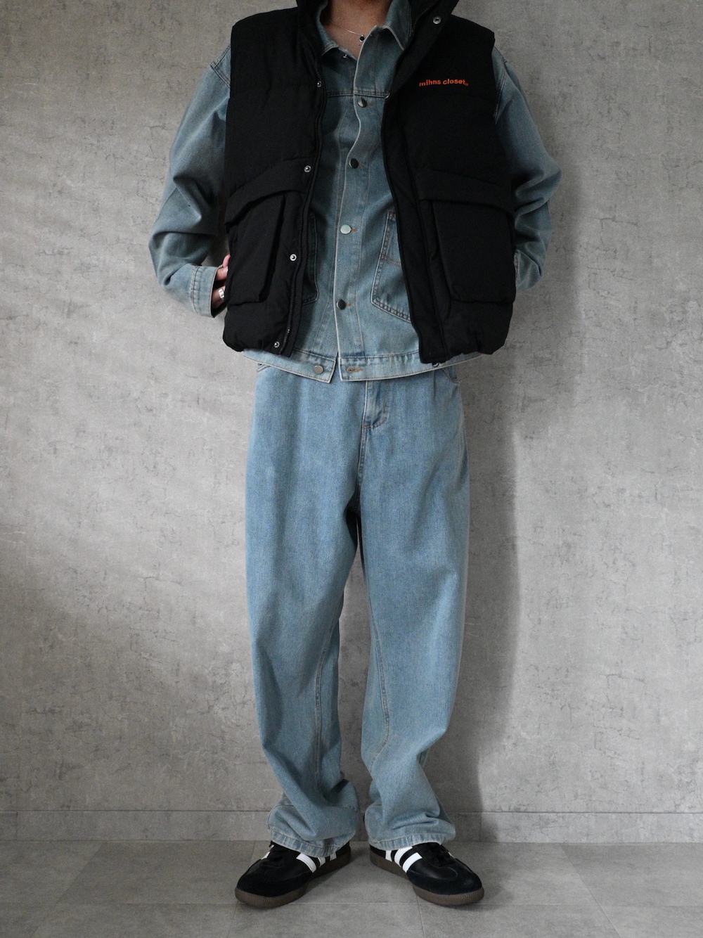 ブラック系のダウンベスト、ブルー系のデニムジャケット、ブルー系のデニムパンツを着用したメンズの秋コーディネートの1枚目の写真