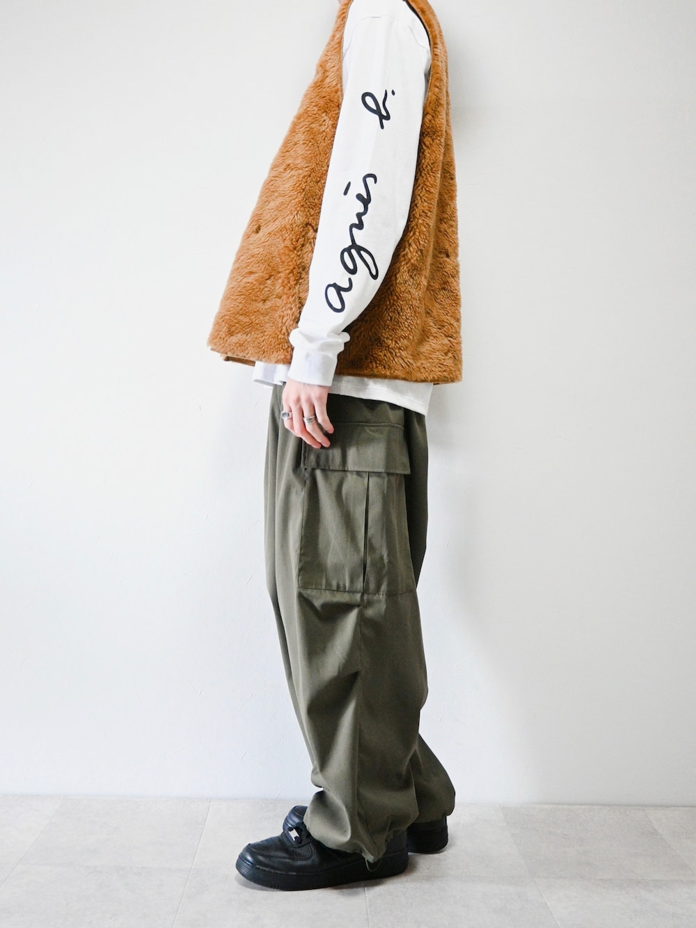 ホワイト系のTシャツ/カットソー、イエロー系のベスト、グリーン系のカーゴパンツを着用したメンズの春コーディネートの1枚目の写真