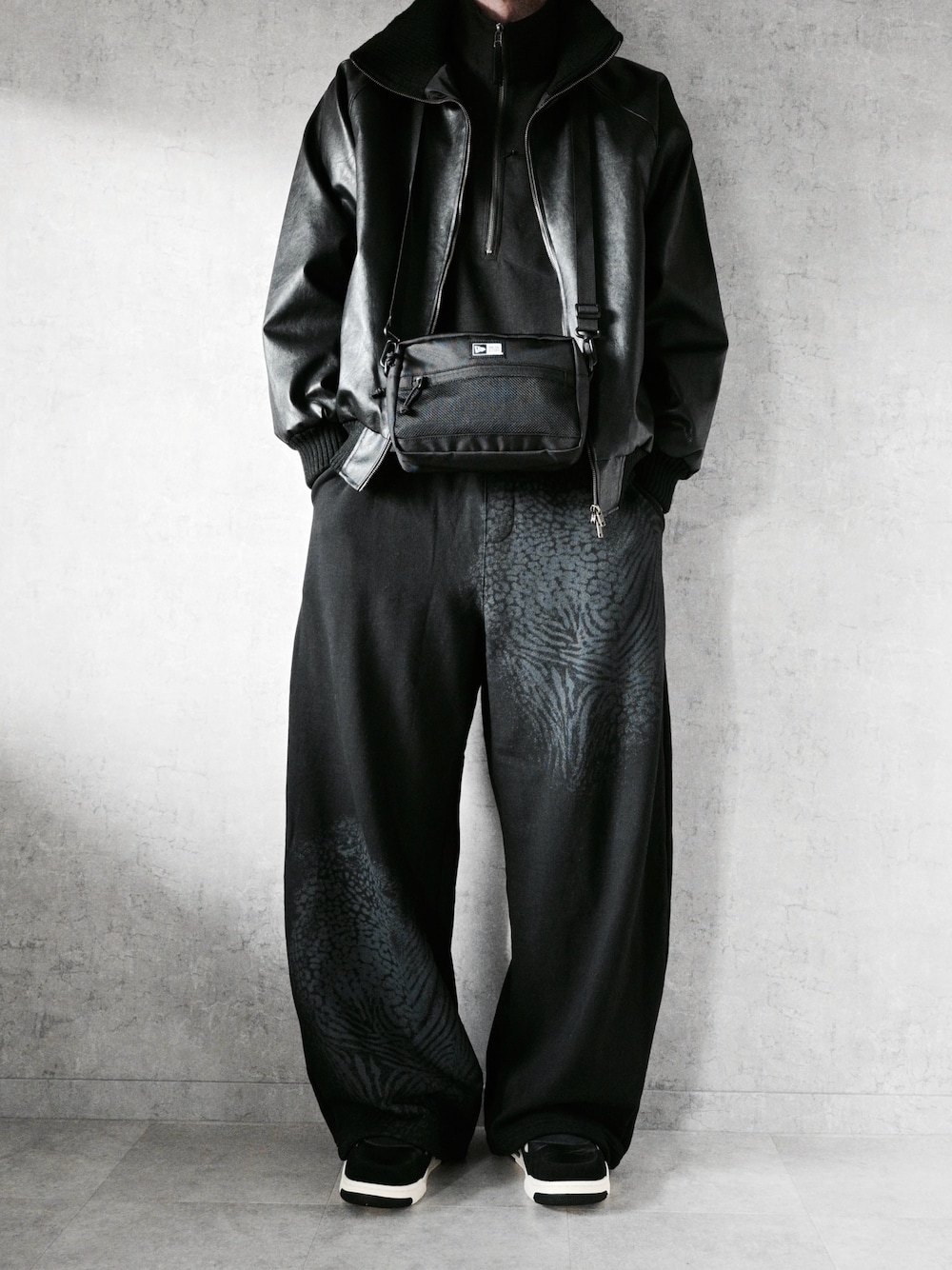 ブラック系のスウェットパンツ、ブラック系のショルダーバッグ、ブラック系のトップスを着用したメンズの冬コーディネートの1枚目の写真