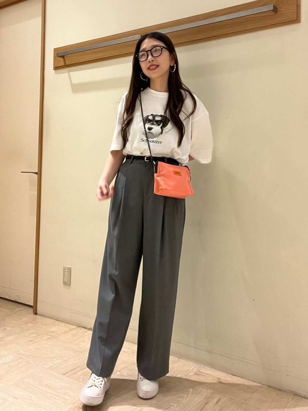 ピンク系のショルダーバッグ、ホワイト系のTシャツ/カットソー、グレー系のスラックスを着用したレディースの夏コーディネートの1枚目の写真