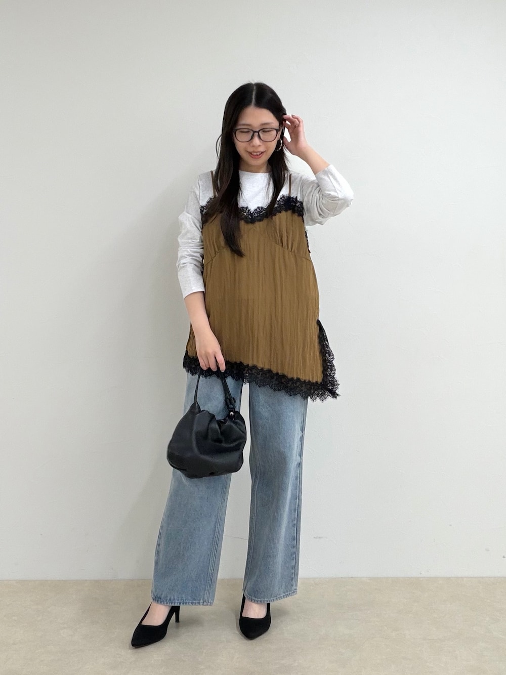 イエロー系のTシャツ/カットソー、ブルー系のデニムパンツを着用したレディースの秋コーディネートの1枚目の写真