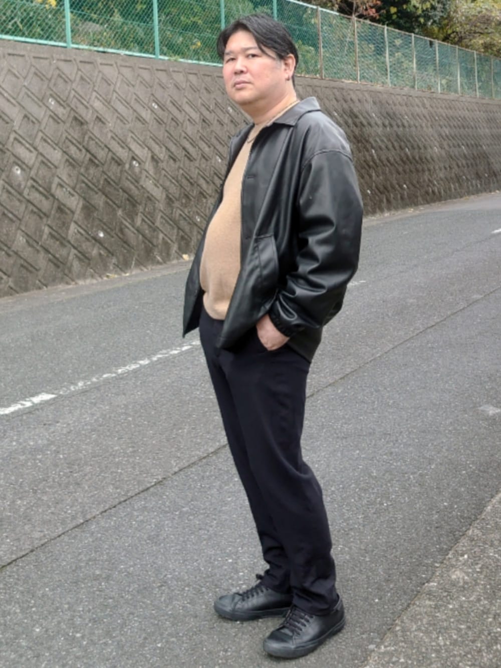 ブラック系のその他アウター、ブラック系のスニーカーを着用したメンズの冬コーディネートの1枚目の写真