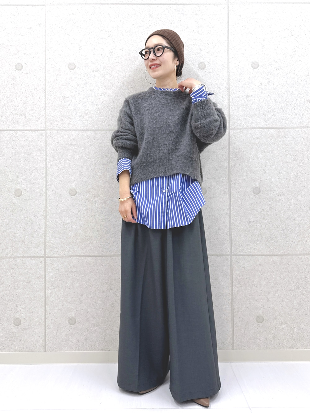 グレー系のその他パンツ、グレー系のニット/セーター、ブルー系のシャツ/ブラウスを着用したレディースの秋コーディネートの1枚目の写真