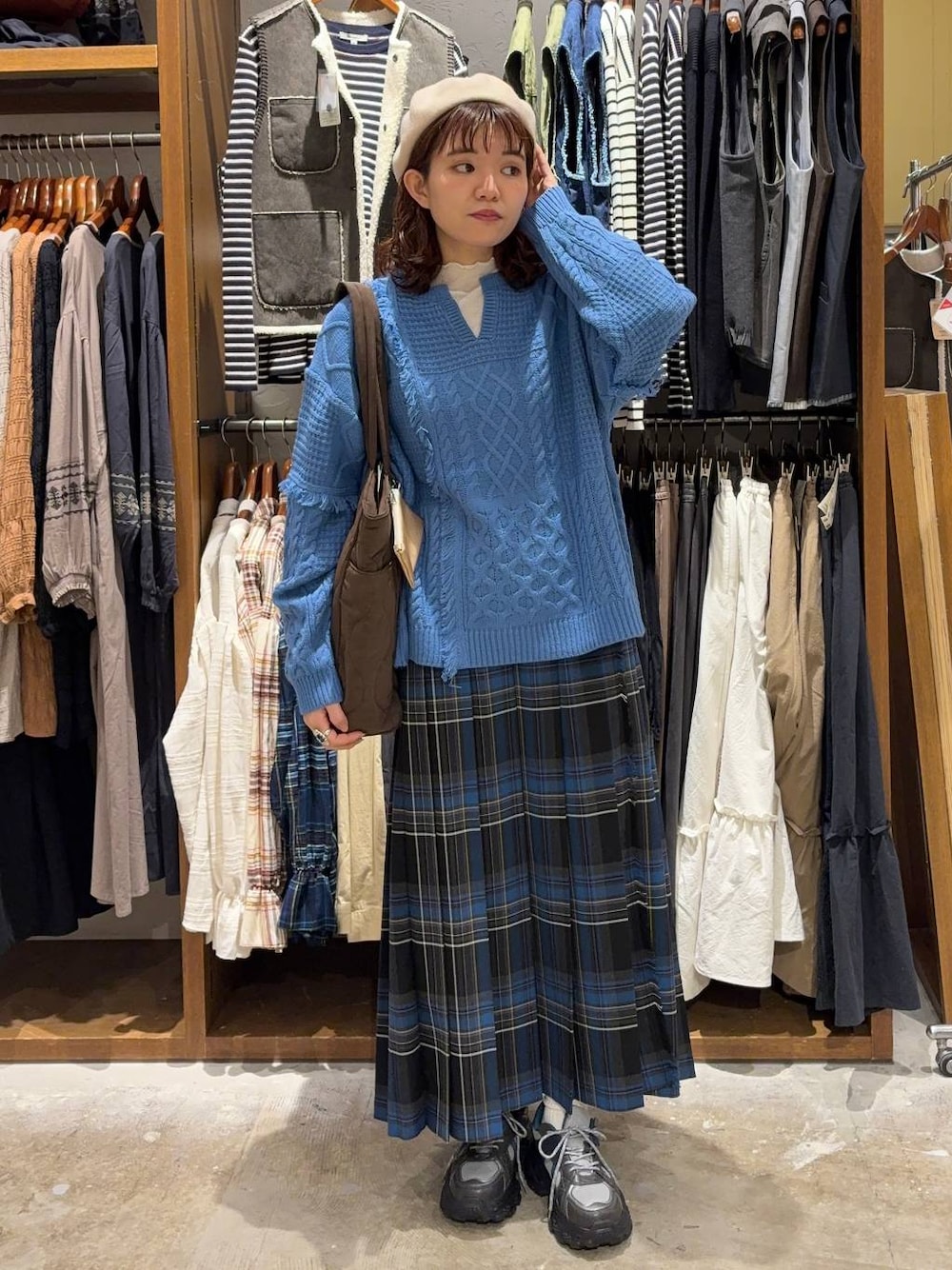 ブラック系のスカート、ホワイト系のTシャツ/カットソー、グレー系のスニーカーを着用したレディースの秋コーディネートの1枚目の写真