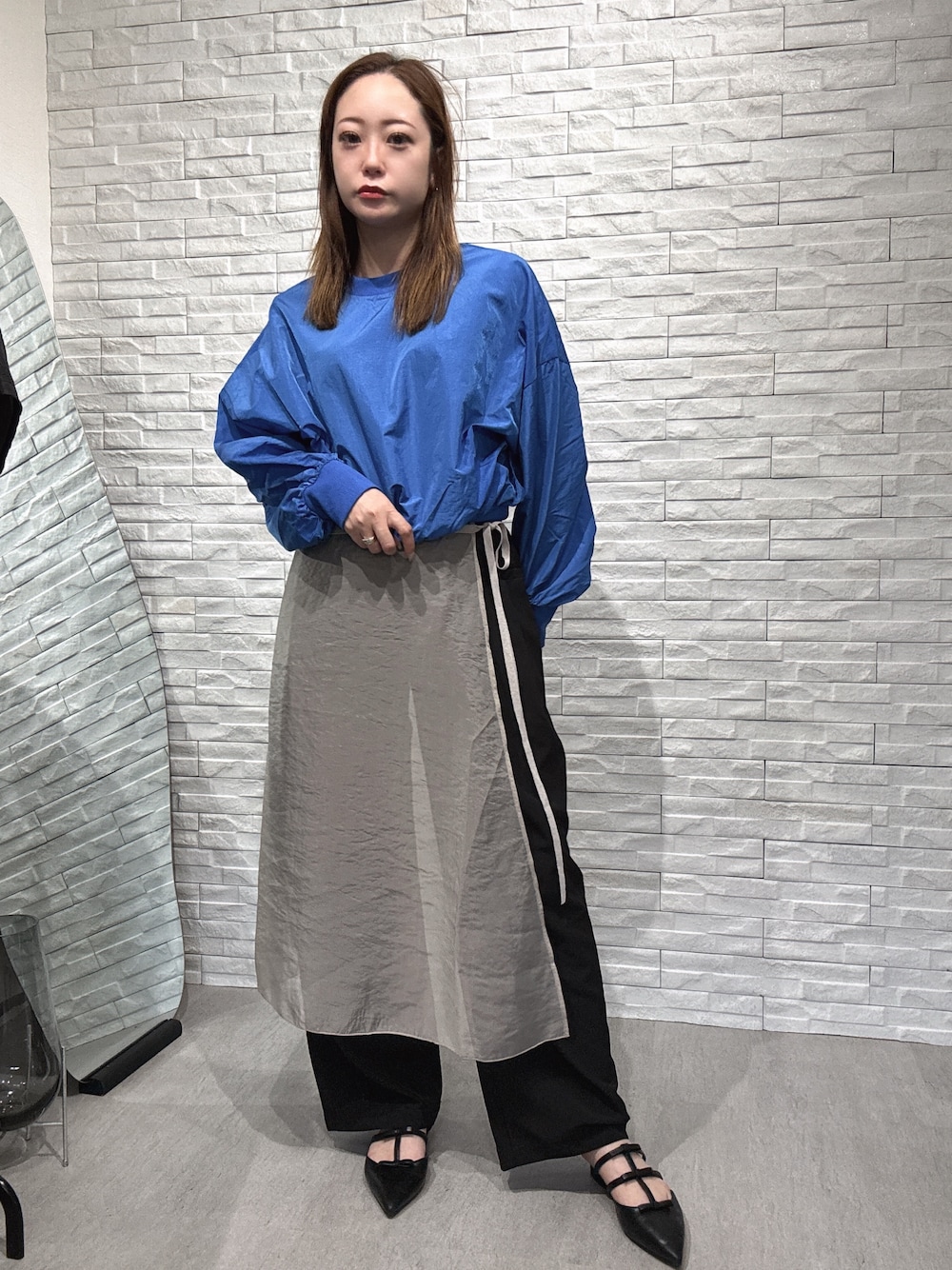 ブルー系のシャツ/ブラウス、ベージュ系のスカート、ブラック系のその他パンツを着用したレディースの春コーディネートの1枚目の写真