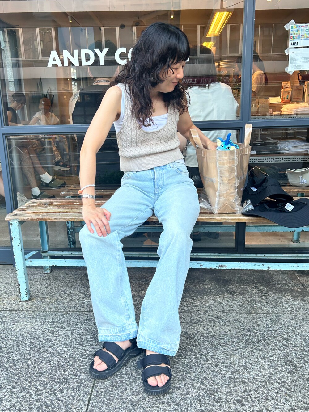 ブラック系のサンダル、ホワイト系のタンクトップ、ブルー系のデニムパンツを着用したレディースの夏コーディネートの1枚目の写真