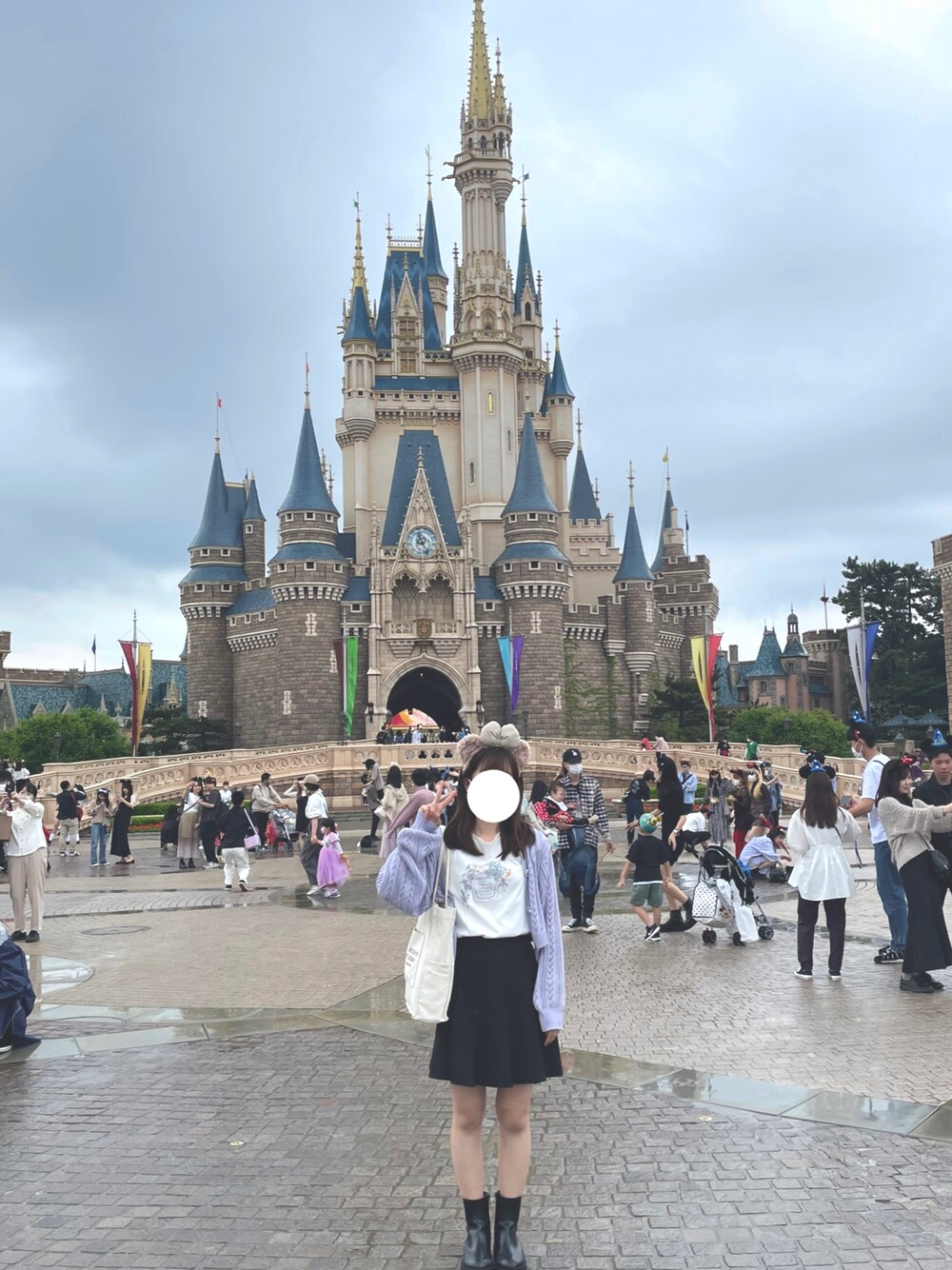 ブラック系のスカート、ホワイト系のTシャツ/カットソー、ブラック系のブーツを着用したレディースの春コーディネートの1枚目の写真