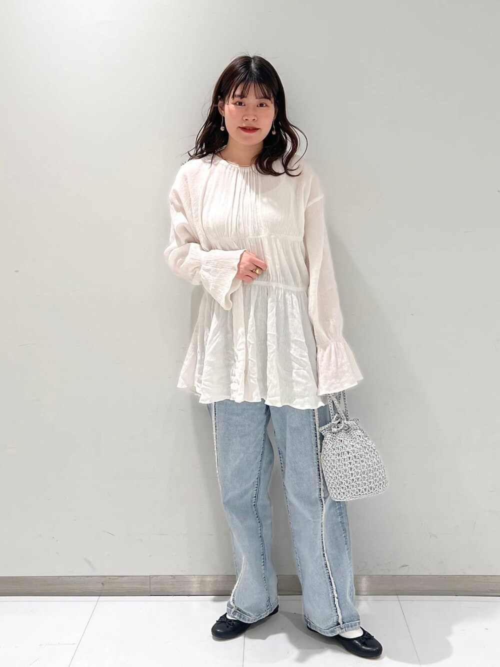 ホワイト系のシャツ/ブラウス、ブラック系のバレエシューズ、ブルー系のデニムパンツを着用したレディースの春コーディネートの1枚目の写真
