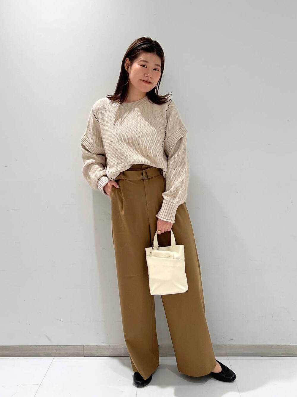ブラック系のバレエシューズ、ホワイト系のTシャツ/カットソー、ホワイト系のショルダーバッグを着用したレディースの秋コーディネートの1枚目の写真