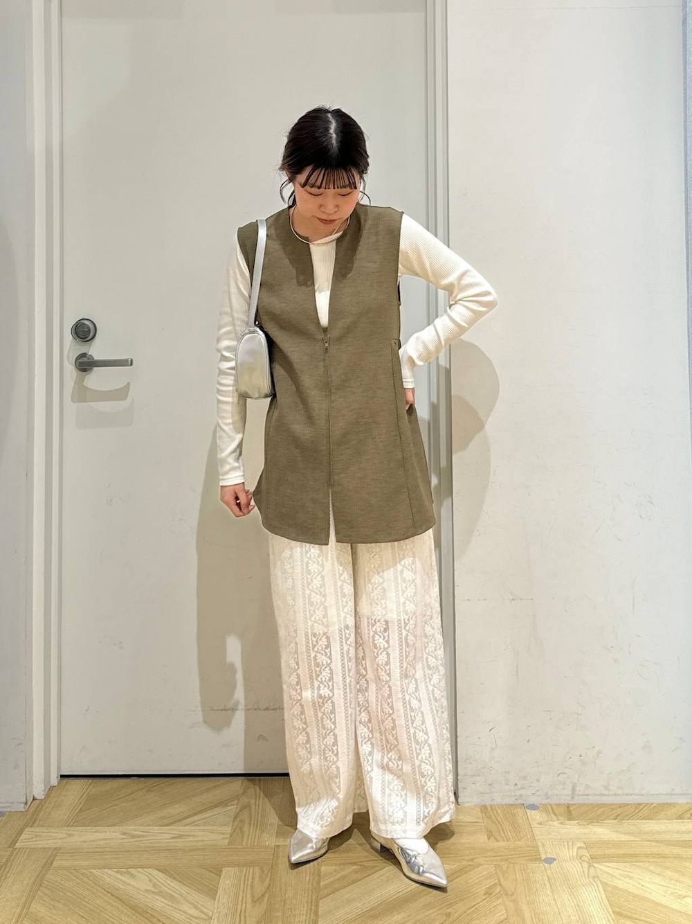 ブラウン系のベスト、ホワイト系のTシャツ/カットソー、シルバー系のトートバッグを着用したレディースの春コーディネートの1枚目の写真