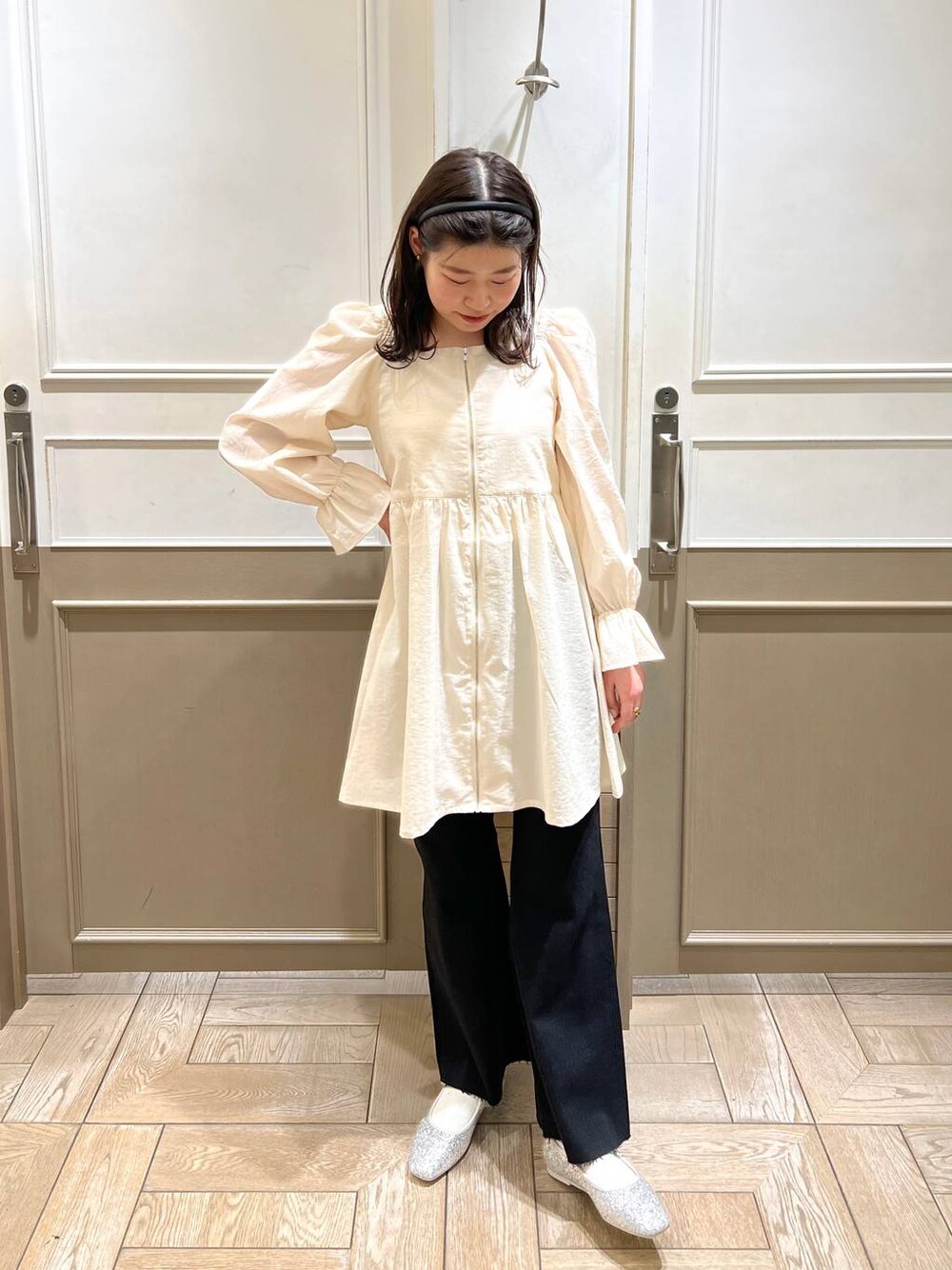 シルバー系のパンプス、ブラック系のデニムパンツ、ホワイト系のTシャツ/カットソーを着用したレディースの冬コーディネートの1枚目の写真