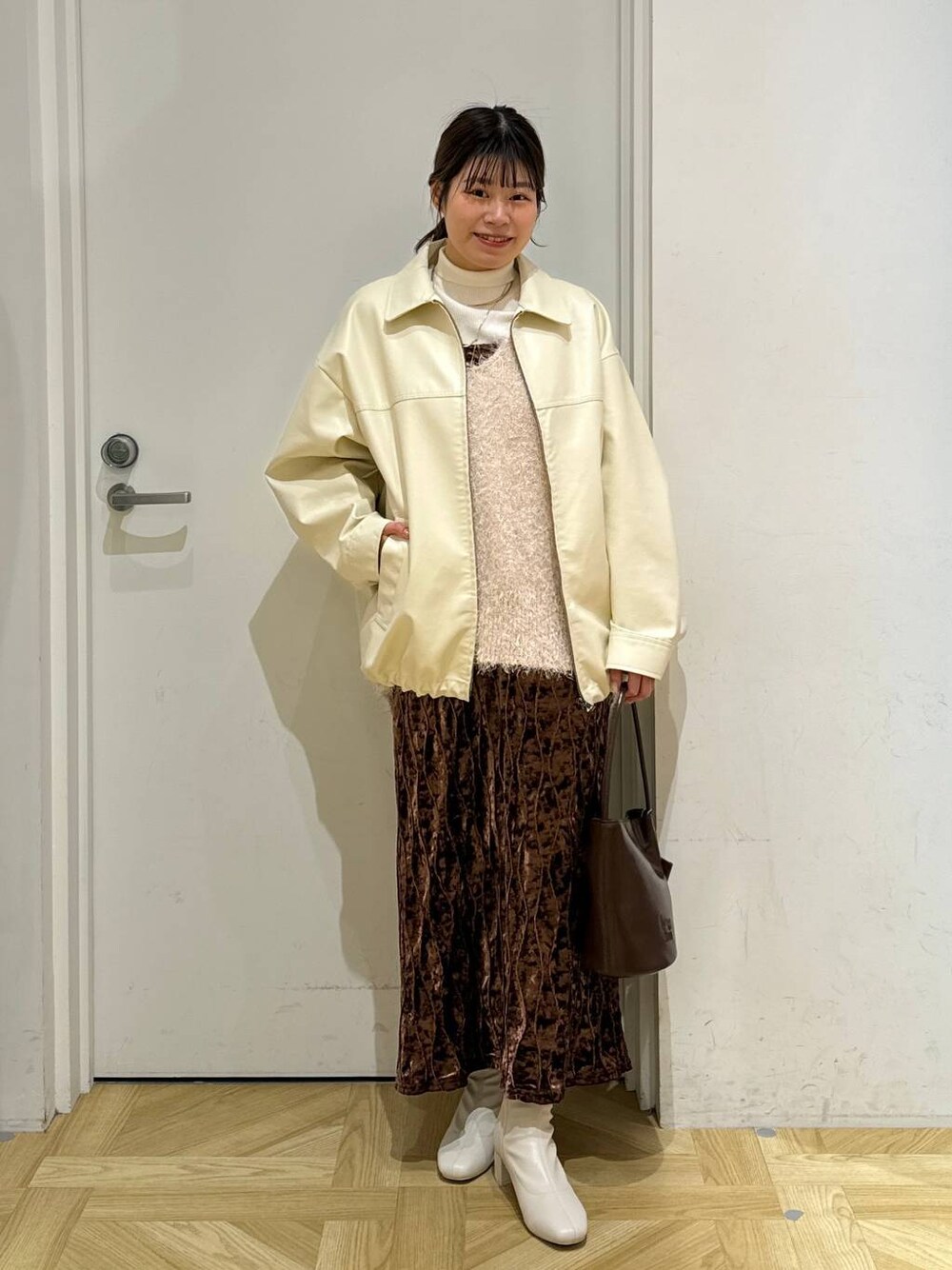 ホワイト系のニット/セーター、ホワイト系のブーツ、ブラウン系のワンピースを着用したレディースの冬コーディネートの1枚目の写真