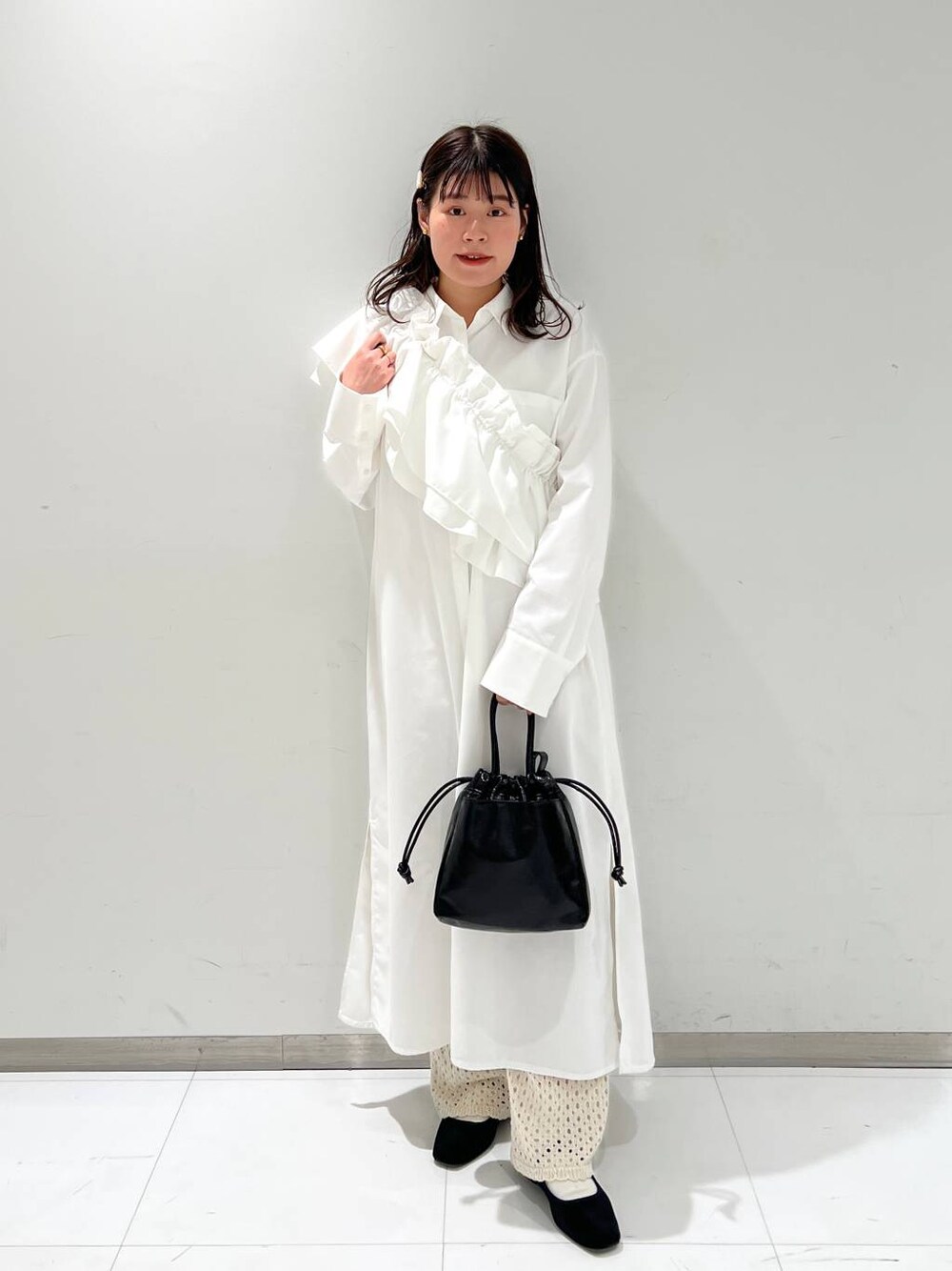 ホワイト系のその他パンツ、その他のパンプス、ブラック系のハンドバッグを着用したレディースの冬コーディネートの1枚目の写真