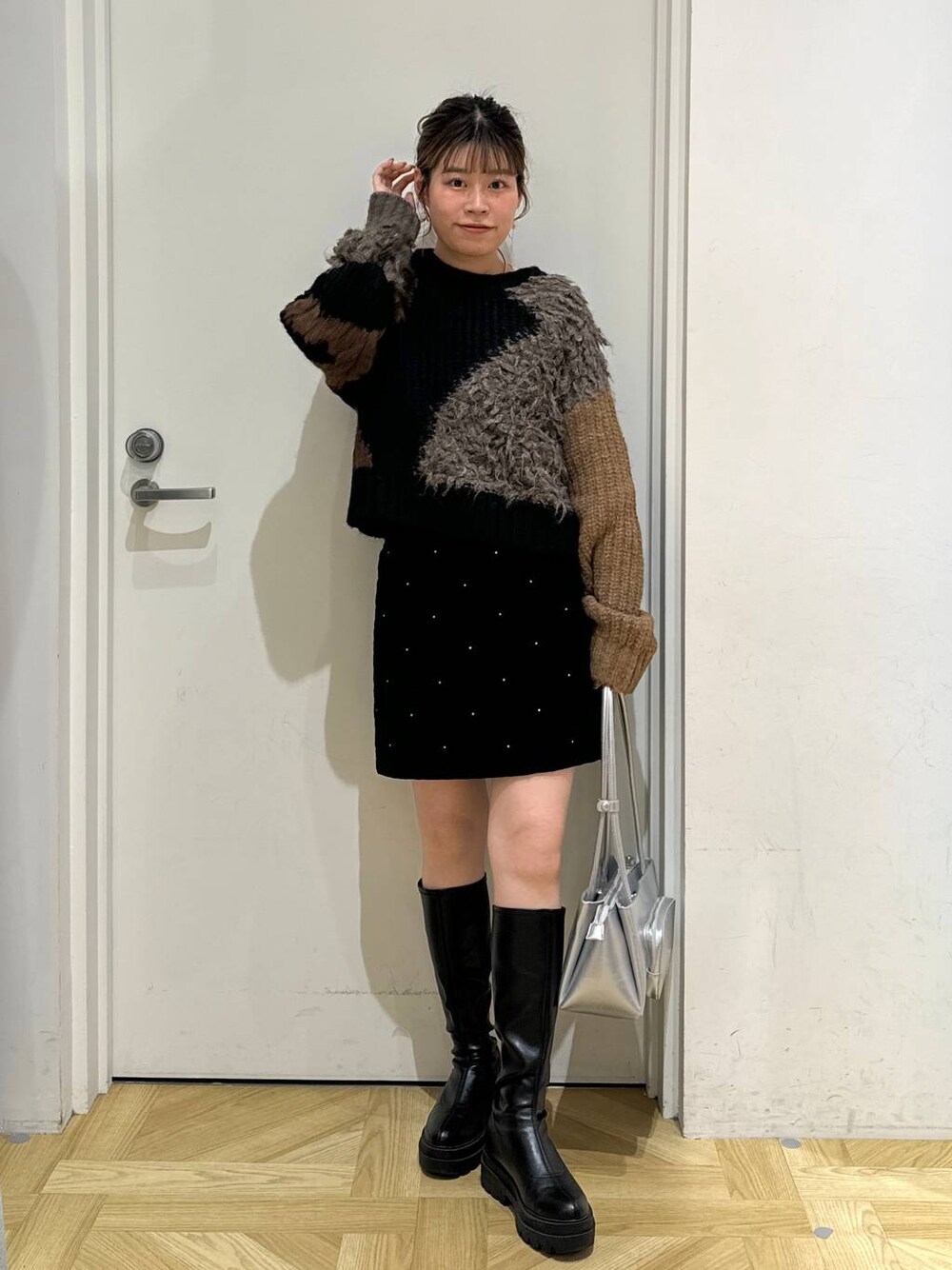 ブラック系のブーツ、シルバー系のショルダーバッグ、ブラック系のニット/セーターを着用したレディースの秋コーディネートの1枚目の写真