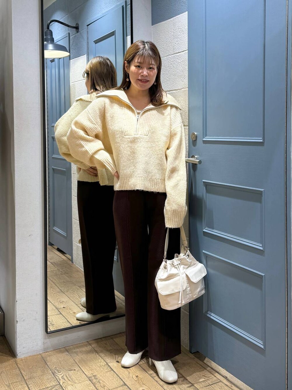 ホワイト系のショルダーバッグ、ホワイト系のブーツ、ホワイト系のニット/セーターを着用したレディースの秋コーディネートの1枚目の写真