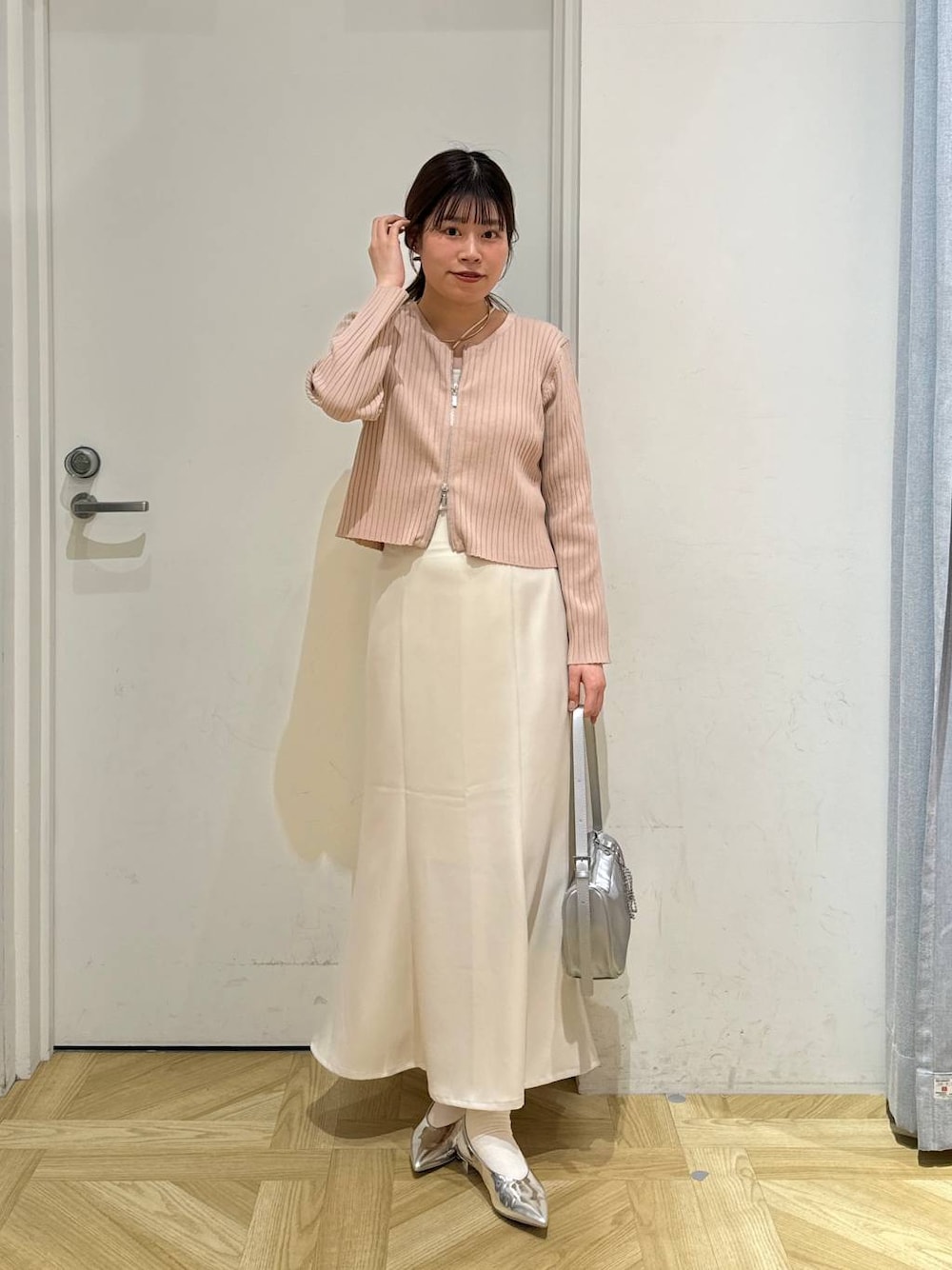 ピンク系のカーディガン/ボレロ、シルバー系のトートバッグ、シルバー系のパンプスを着用したレディースの春コーディネートの1枚目の写真
