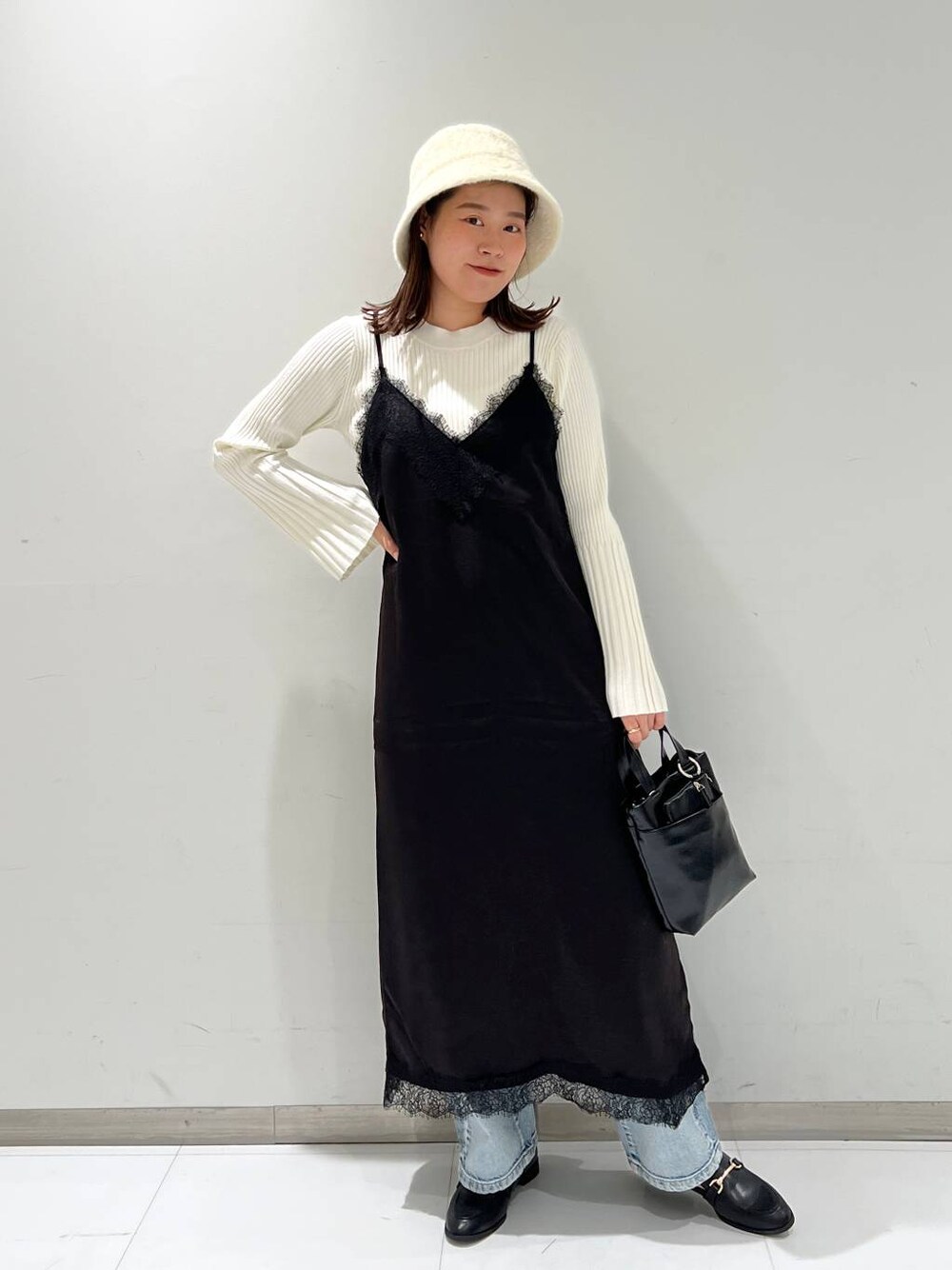 ブルー系のデニムパンツ、ブラック系のローファー、ホワイト系のニット/セーターを着用したレディースの秋コーディネートの1枚目の写真