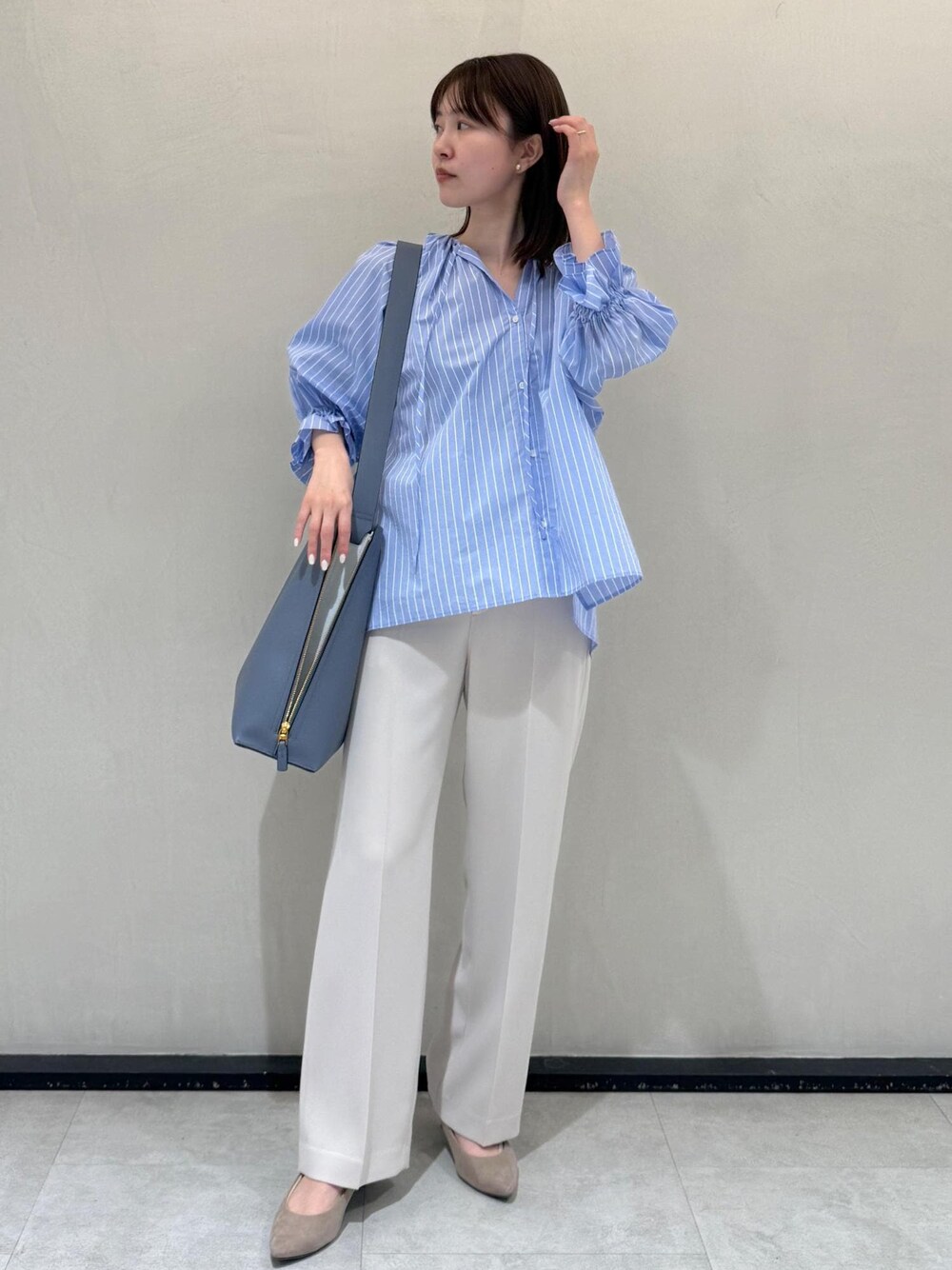 ベージュ系のその他パンツ、ブルー系のショルダーバッグ、ブルー系のシャツ/ブラウスを着用したレディースの春コーディネートの1枚目の写真